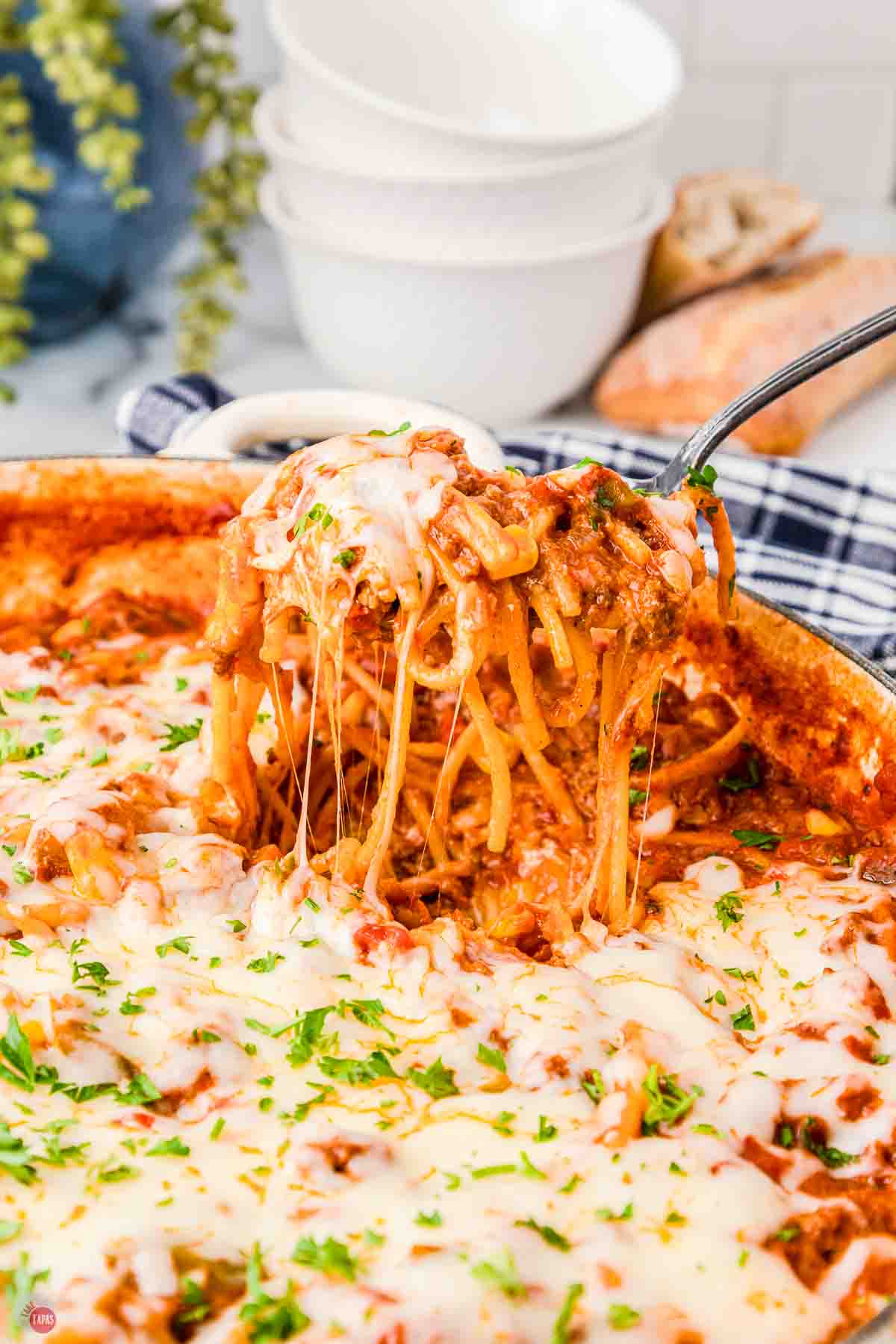 spoon scooping spaghetti out of a skillet
