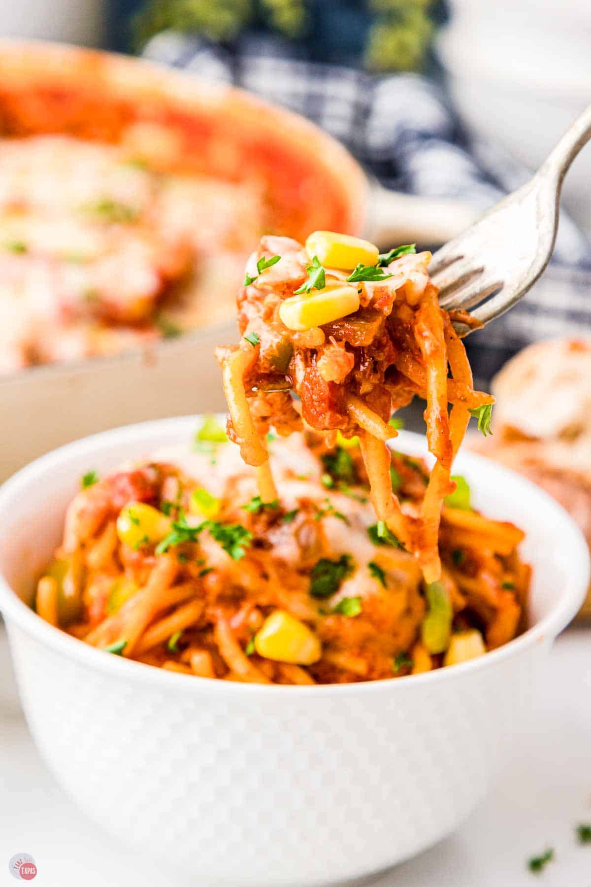 fork with a bite of spaghetti over a bowl