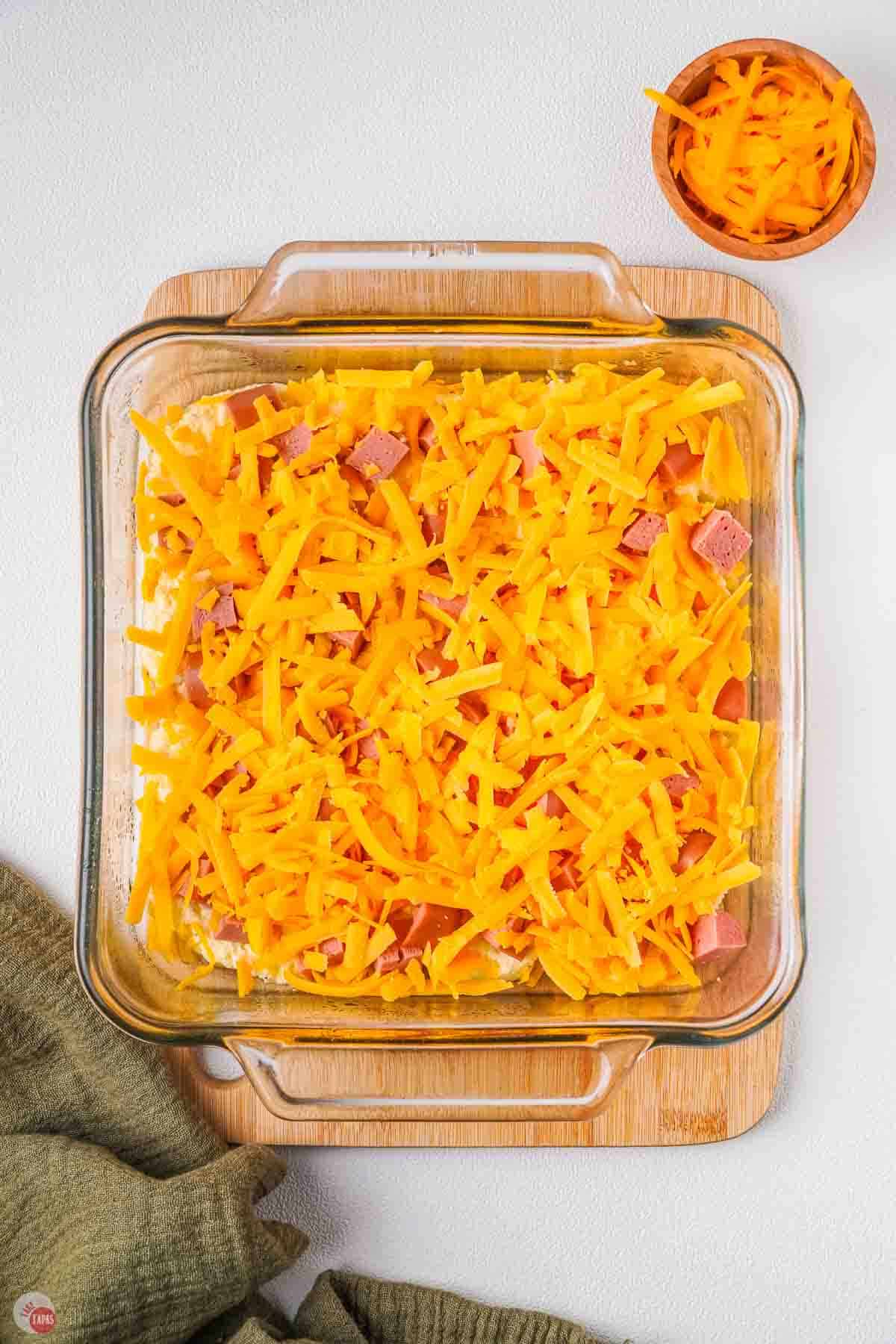 cheese and kielbasa in a clear dish