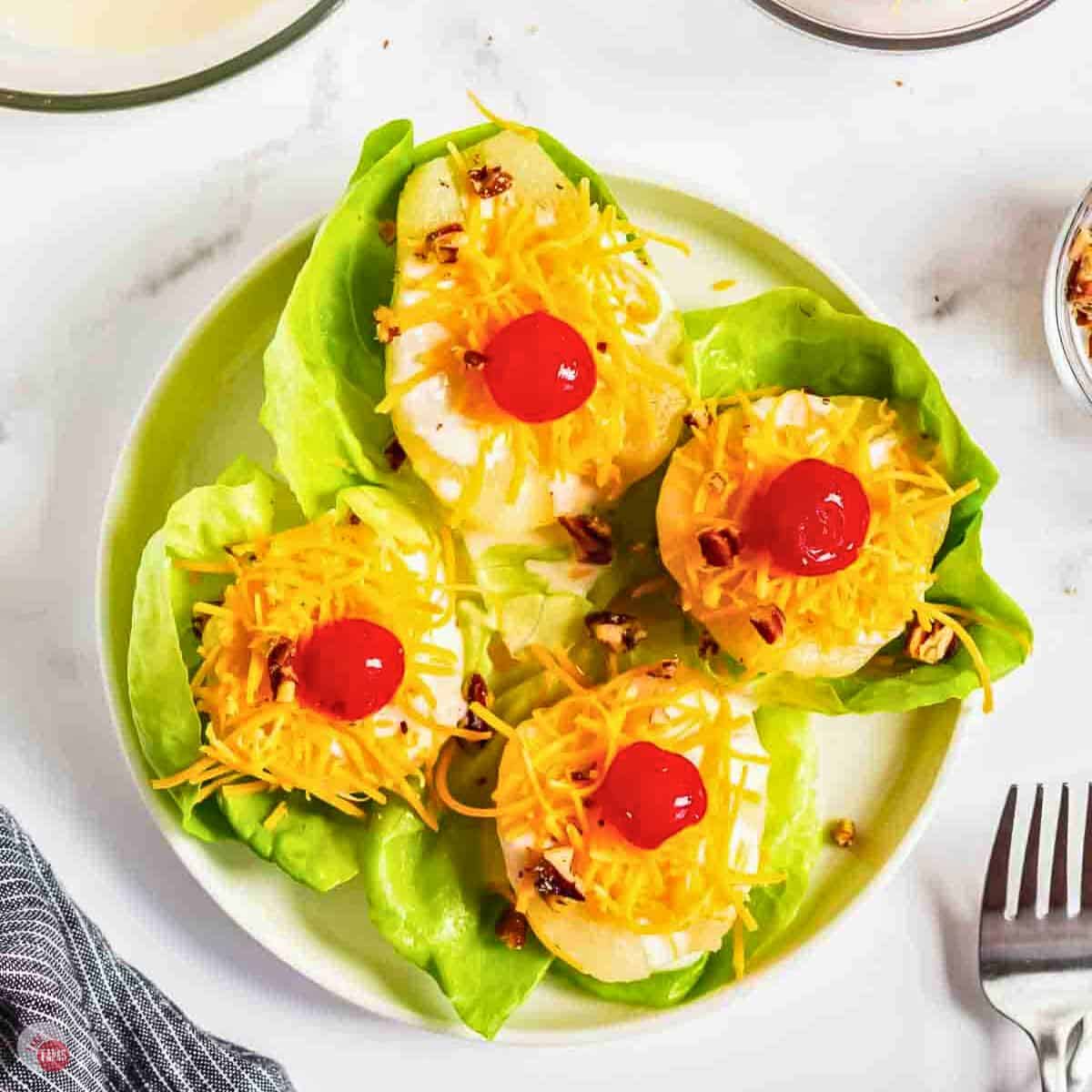 4 pear salads on a white plate with a fork