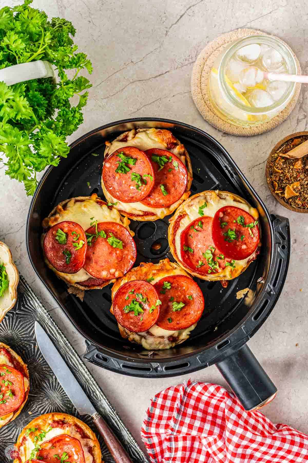 air fryer basket with 4 pepperoni bagels in it