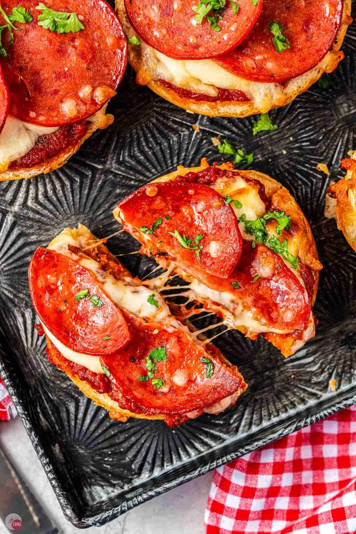 pepperoni pizza bagel cut in half with melted cheese