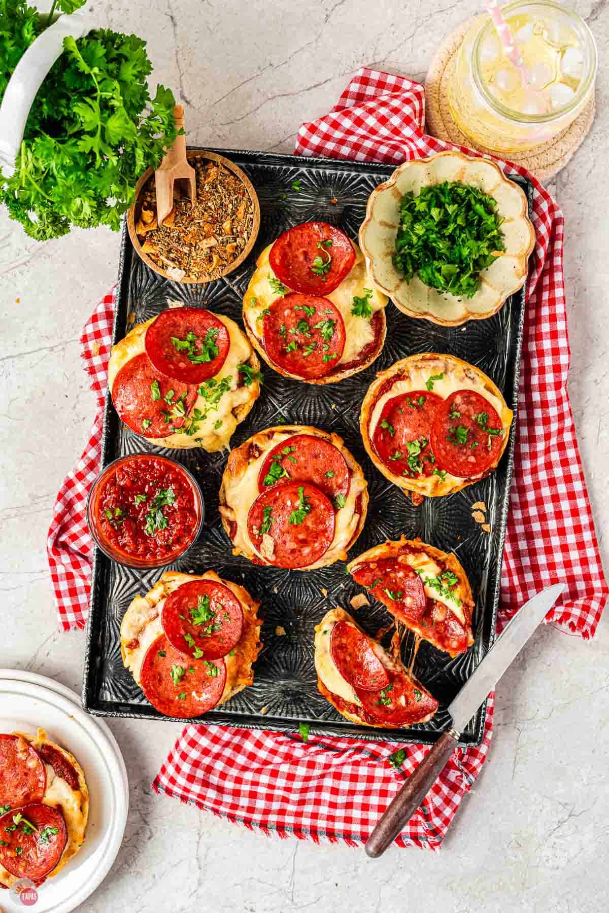 black tray with air fryer pizza bagels on it topped with pepperoni
