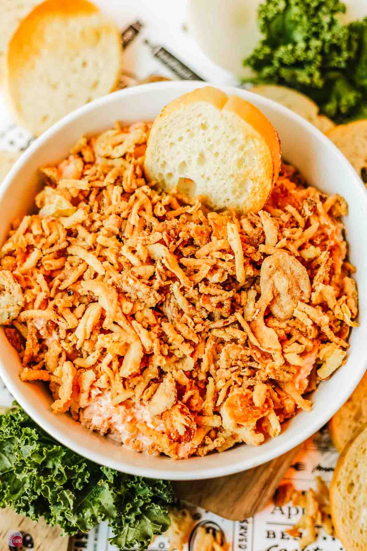 onion dip topped with fried onions and a slice of crostini