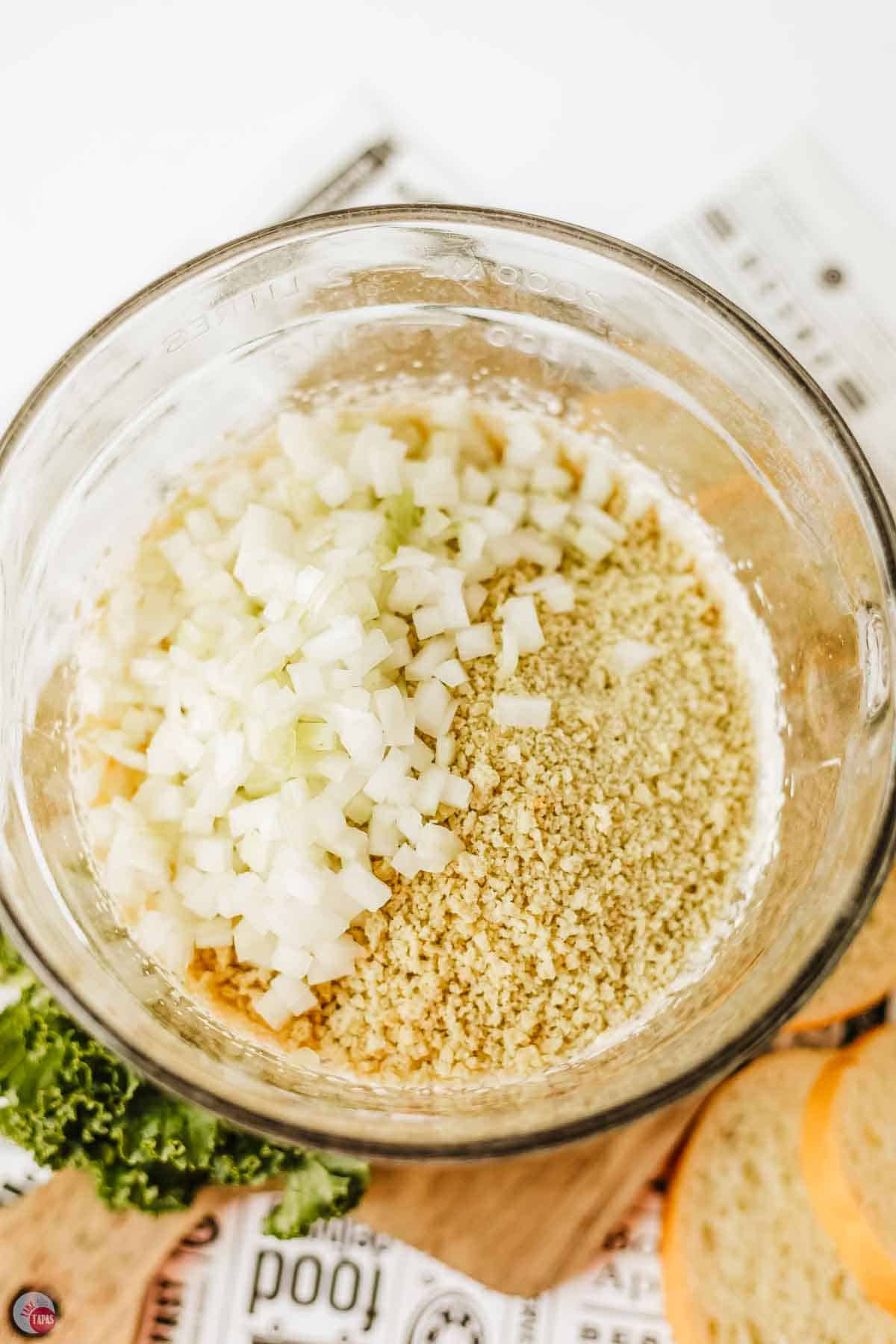 diced onion and bread crumbs in a clear mixing bowl