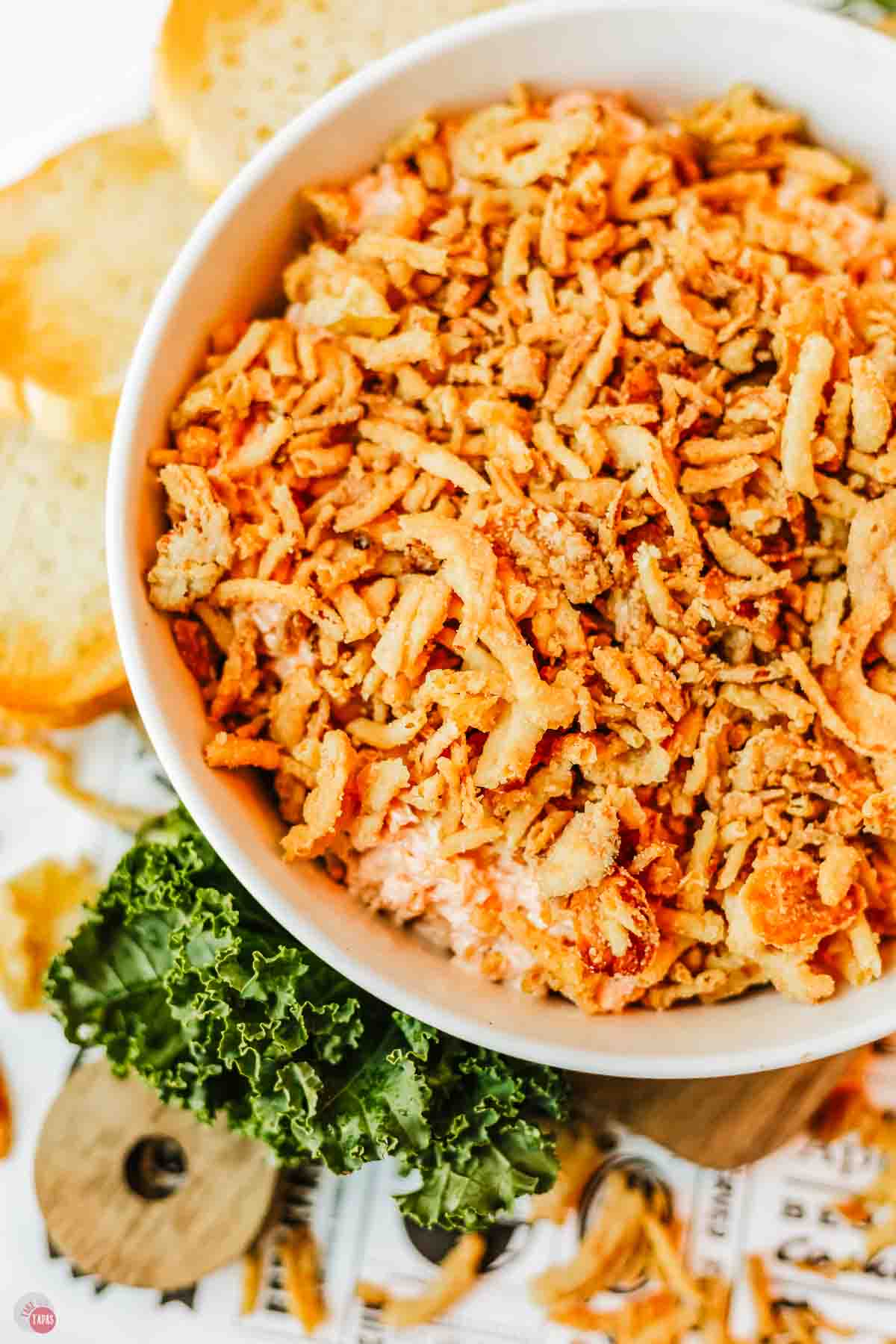 close up of appetizer in a white bowl with fried onions on top