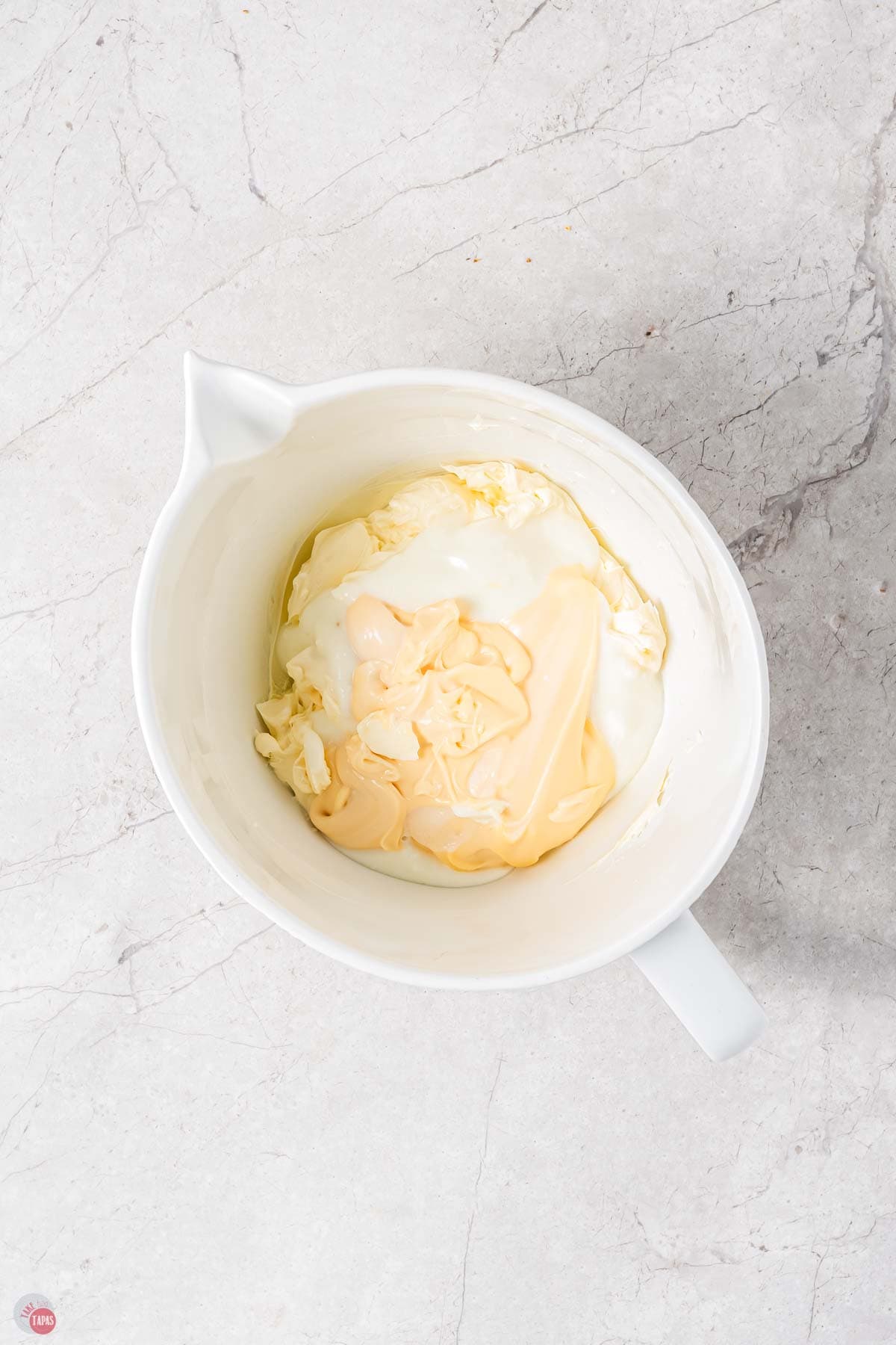 mayo and sour cream in a white mixing bowl