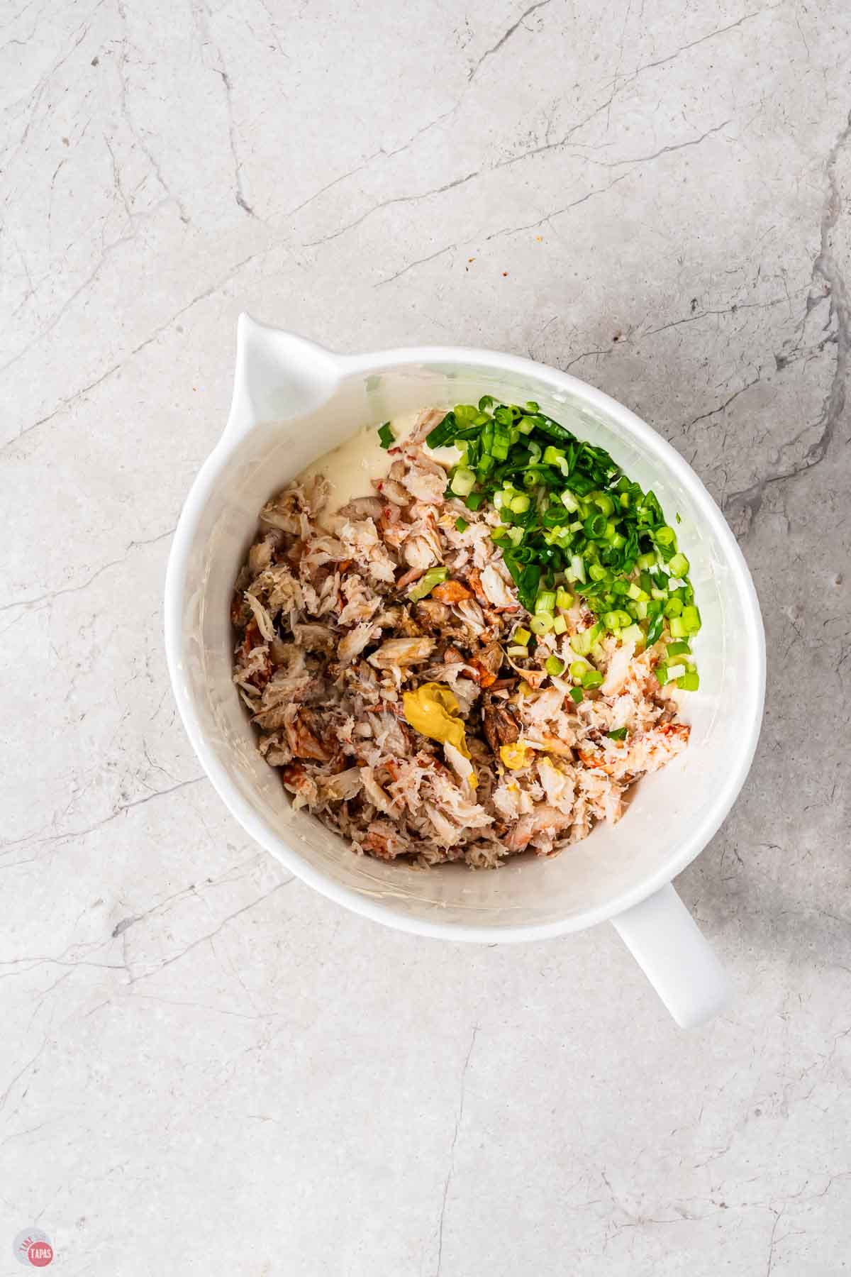 chopped crab and sliced green onion in a white mixing bowl