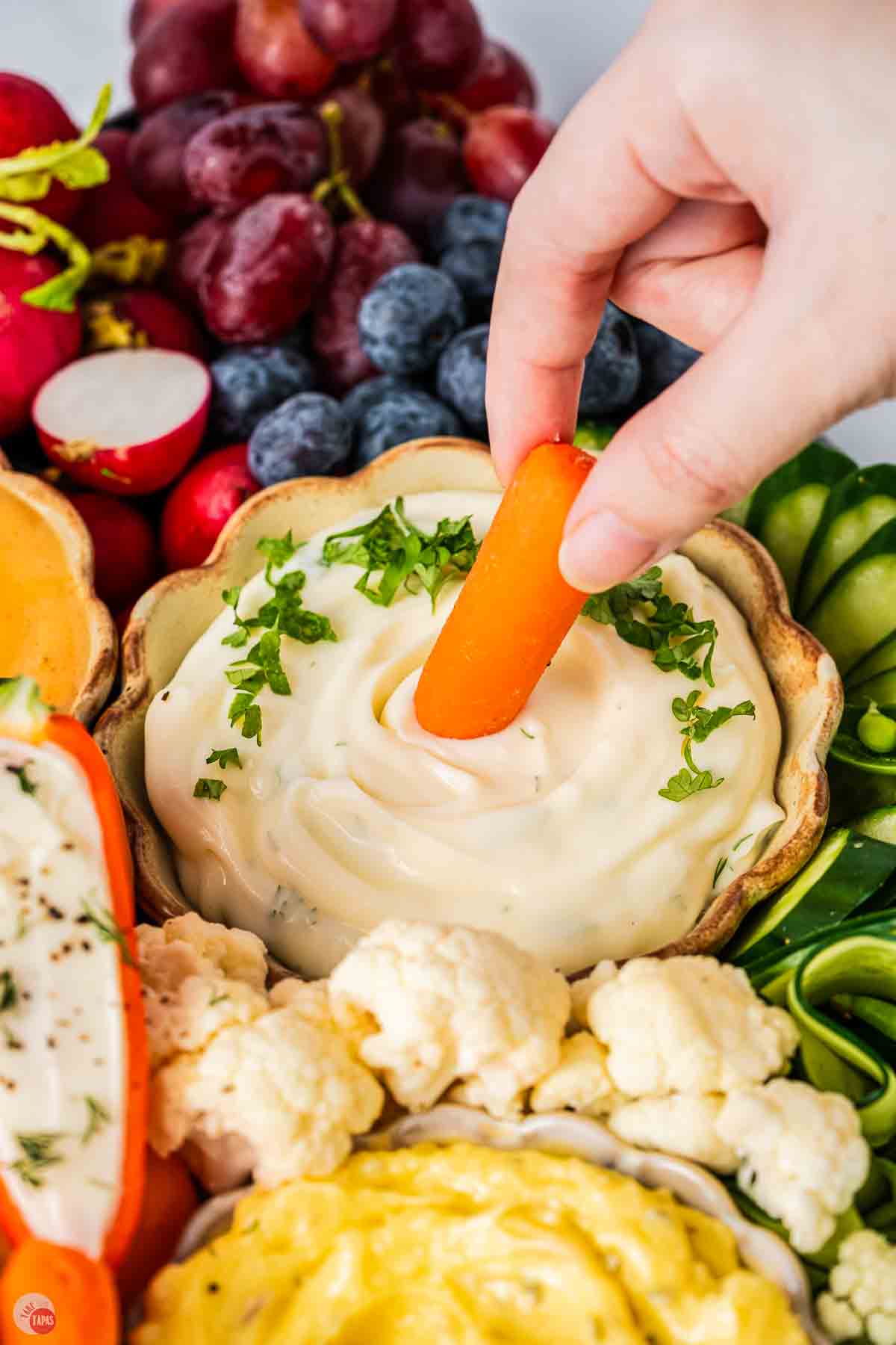 carrot stick dipping in a bowl of ranch dressing