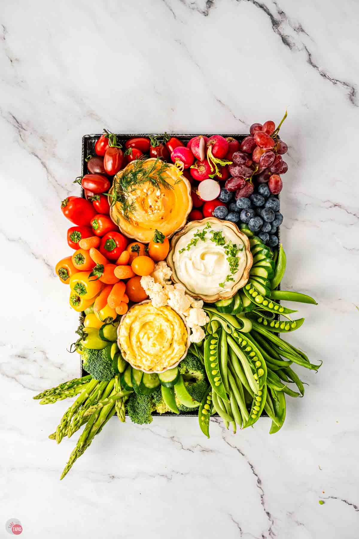 fresh rainbow colored vegetables on a black tray