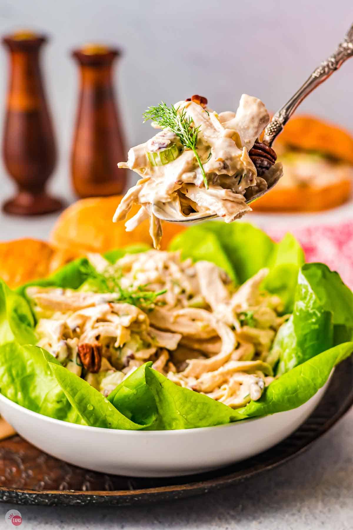 fork with bite of chicken hovering over a bowl