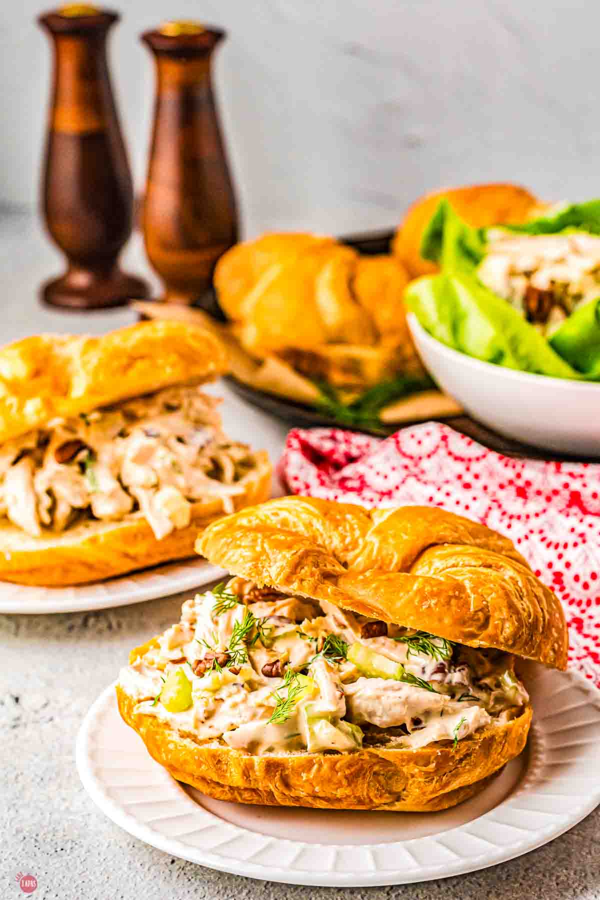 two plates with chicken salad sandwiches on croissants