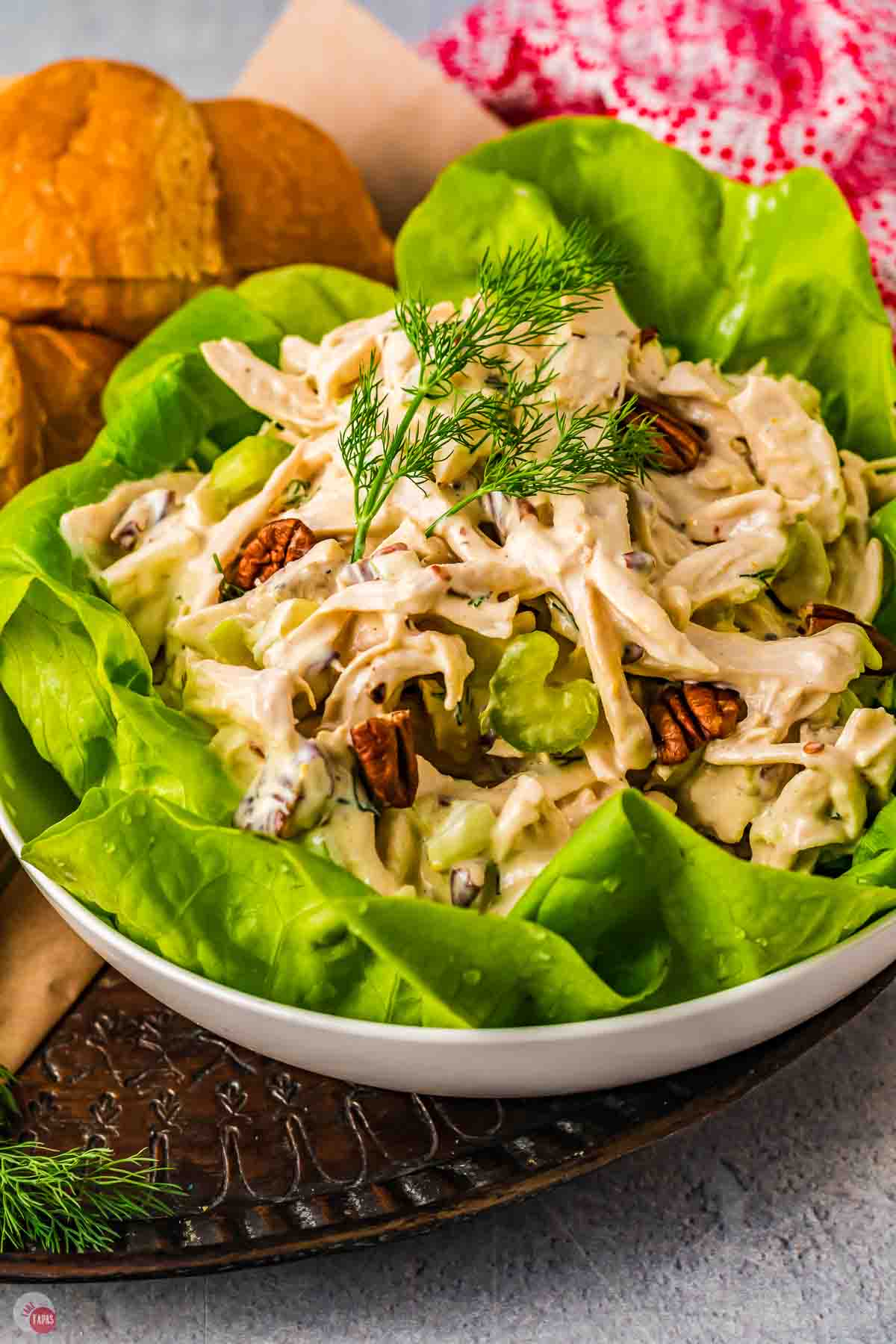 white bowl with large lettuce leaf and a scoop of chicken salad
