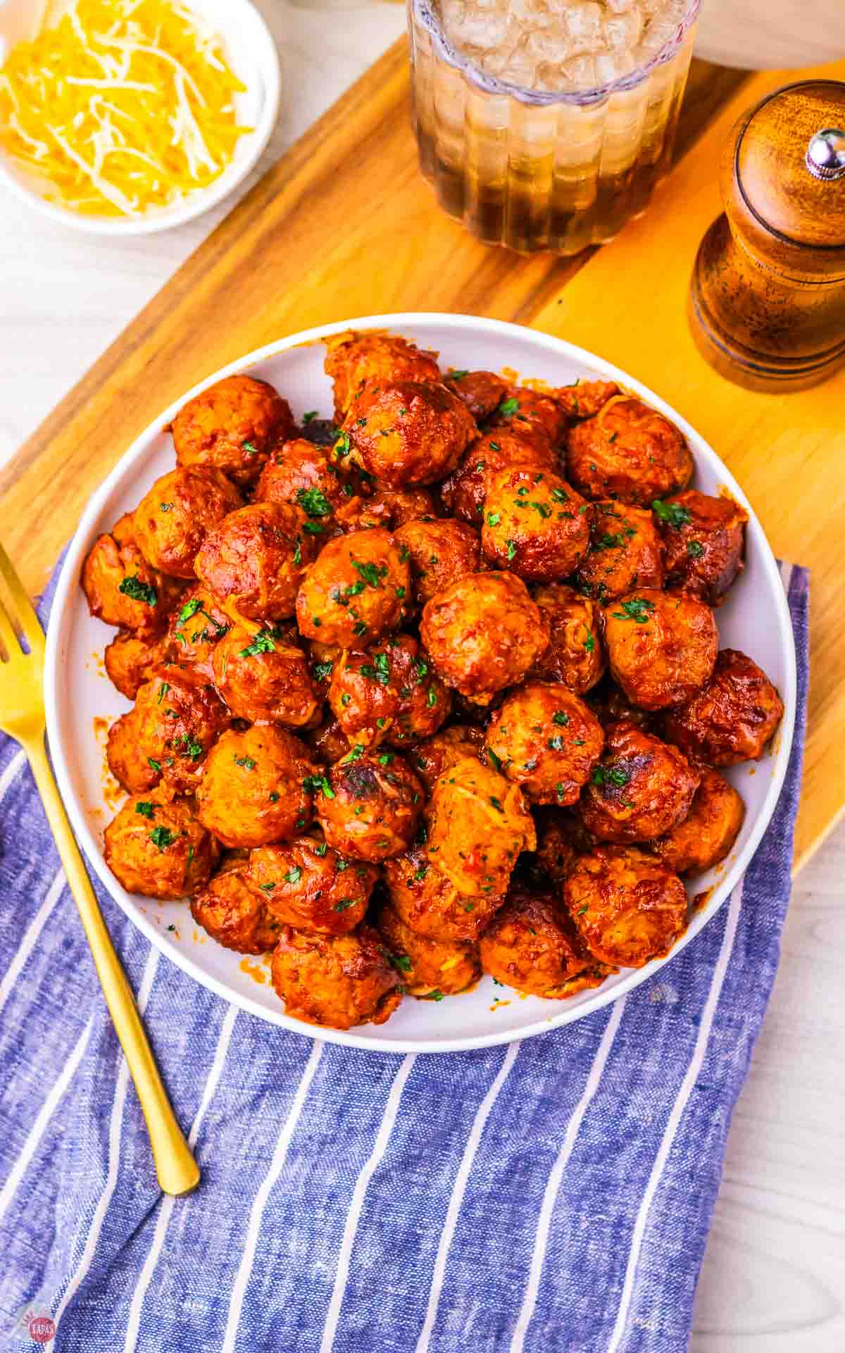 white bowl with meatballs and a blue and white striped napkin