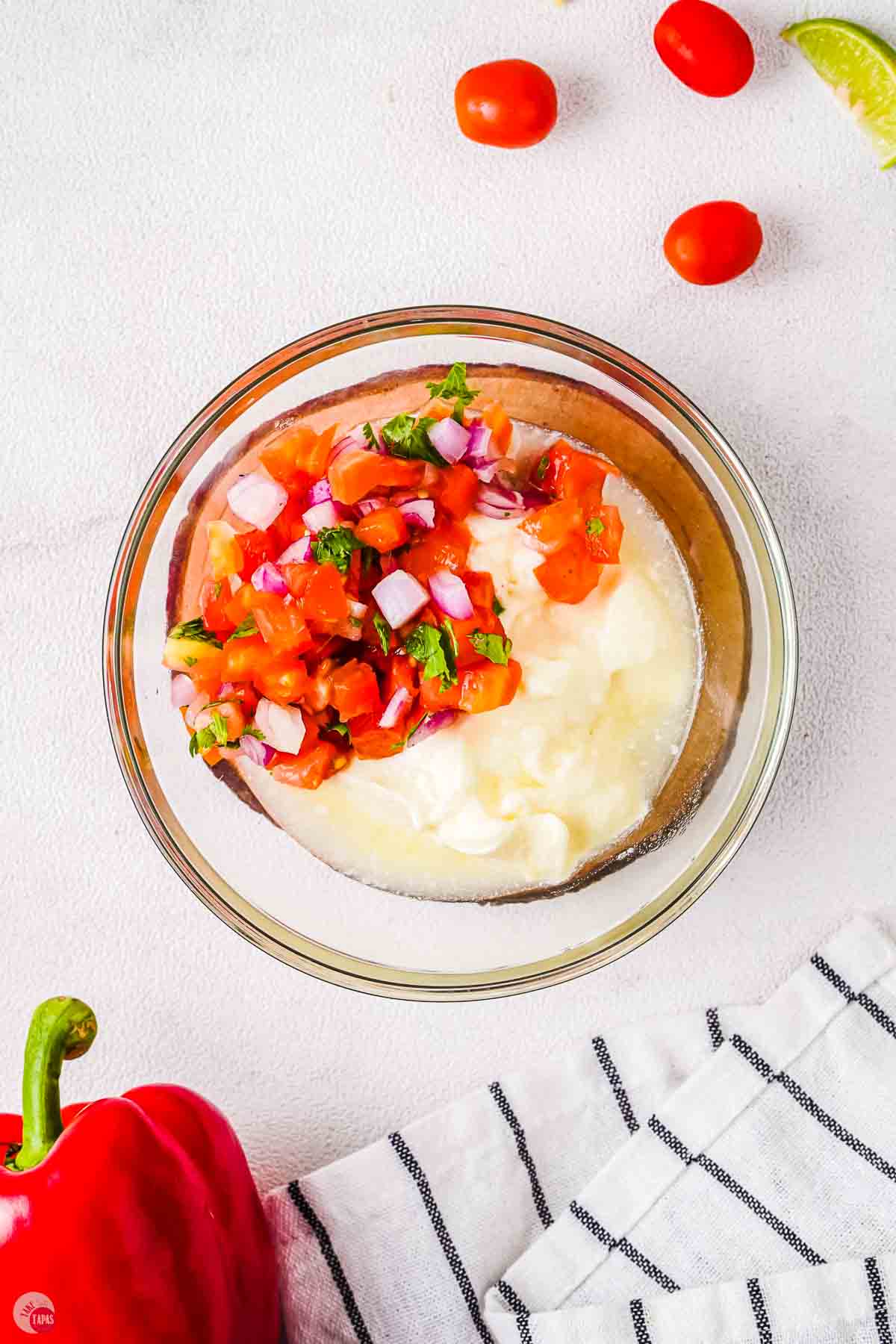 clear bowl with sour cream and pico de gallo in it