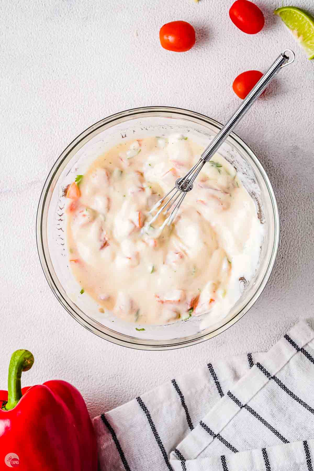 creamy salad dressing in a clear bowl with a spoon