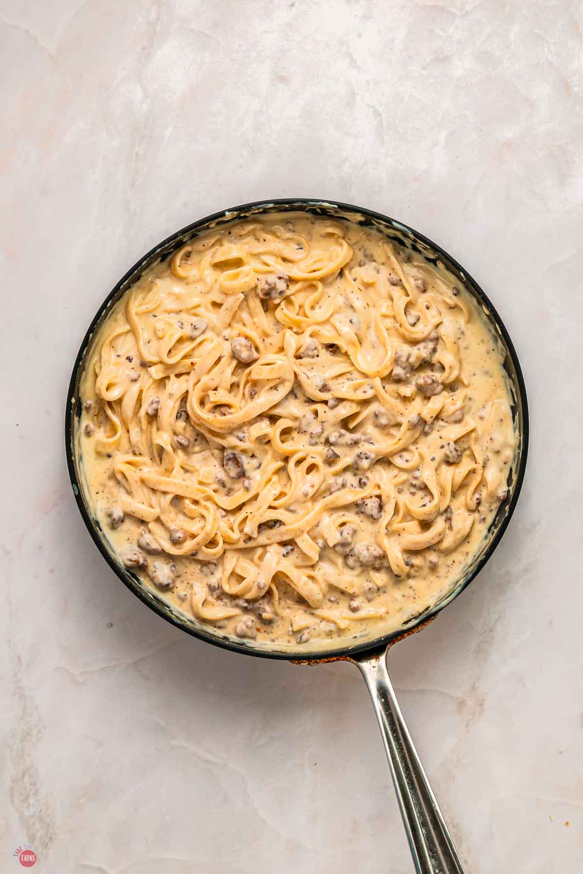 skillet with cream sauce and noodles in it