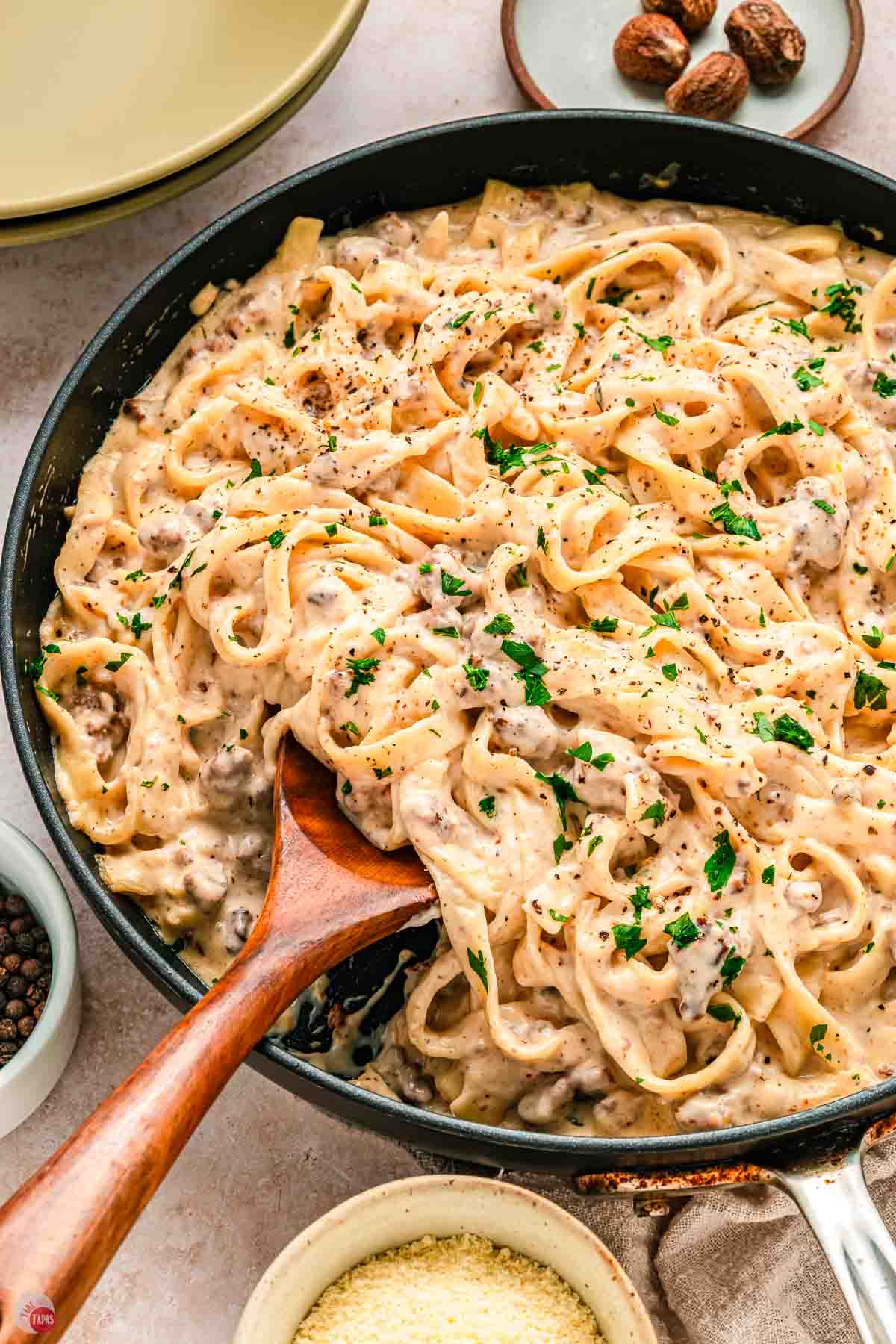wood spoon scooping food out of a skillet
