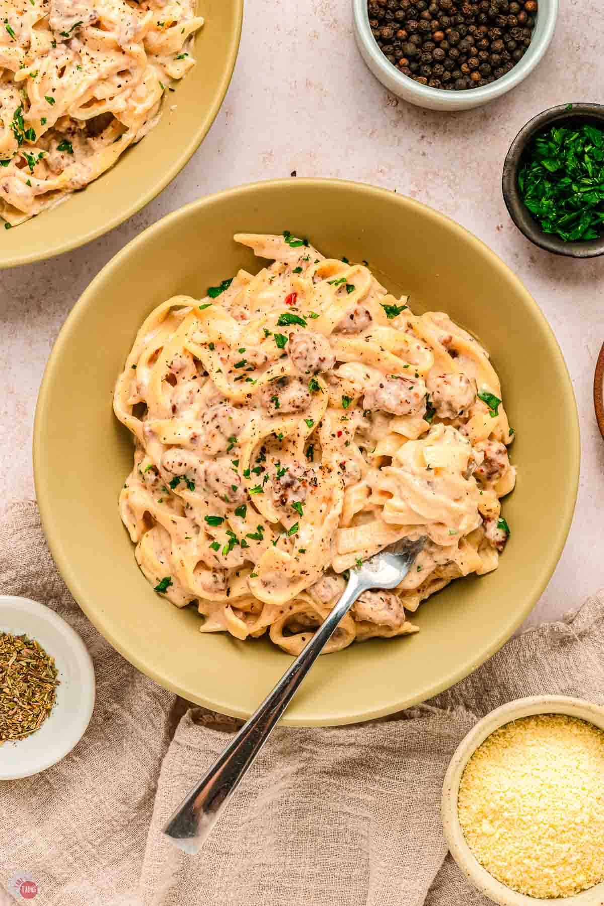 pasta and beef in a bowl with a fork and parsley