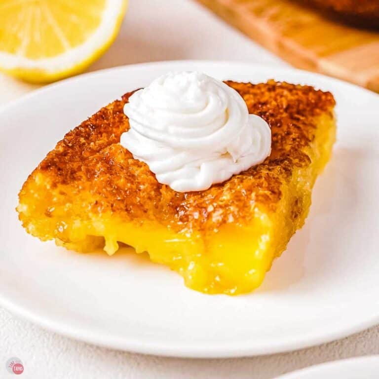 slice of lemon cobbler with whipped cream on a white plate