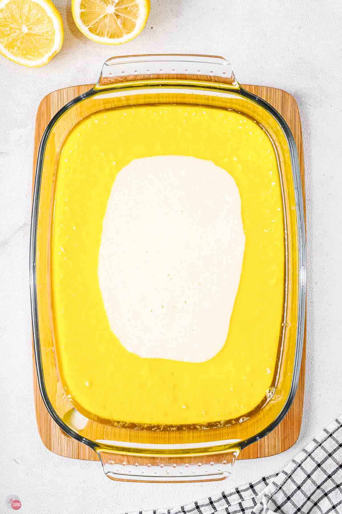casserole dish with cake batter surrounded by melted butter