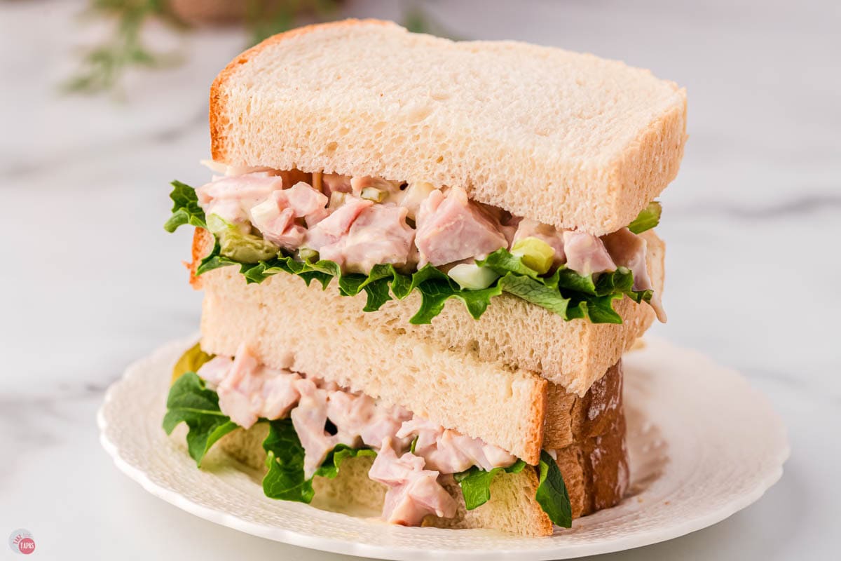 stack of ham salad sandwiches with lettuce on a plate