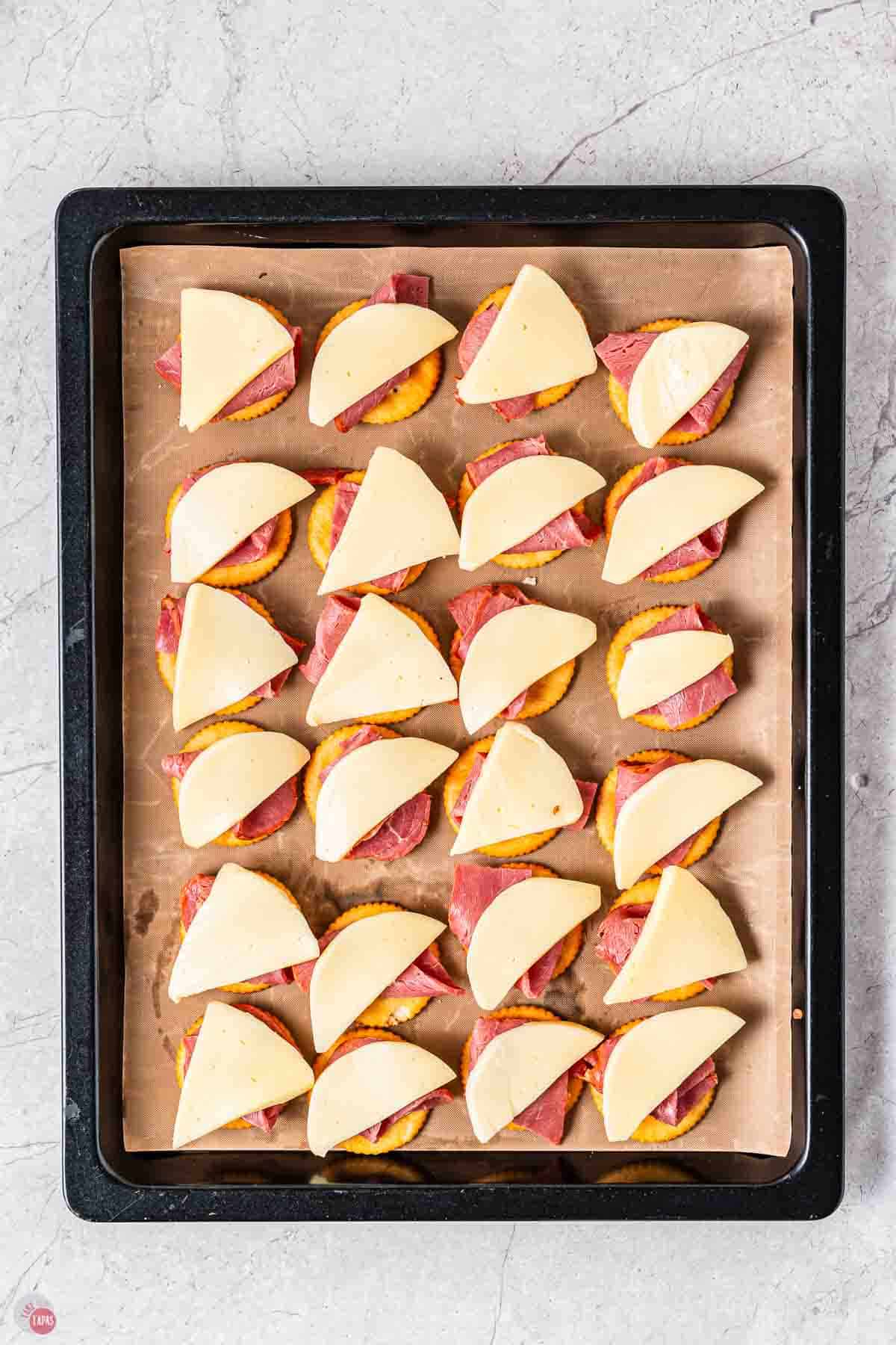 crackers topped with roast beef and pieces of cheese