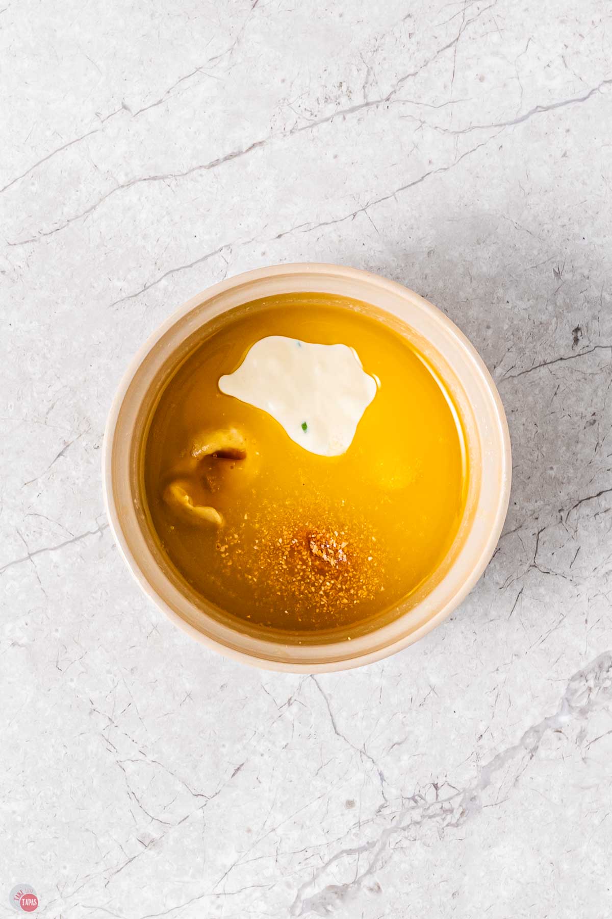 white bowl with melted butter and other ingredients in it unmixed