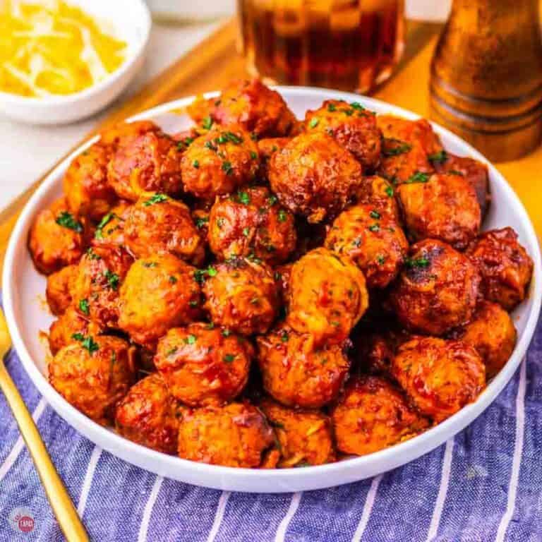 white plate of enchilada meatballs with a gold fork