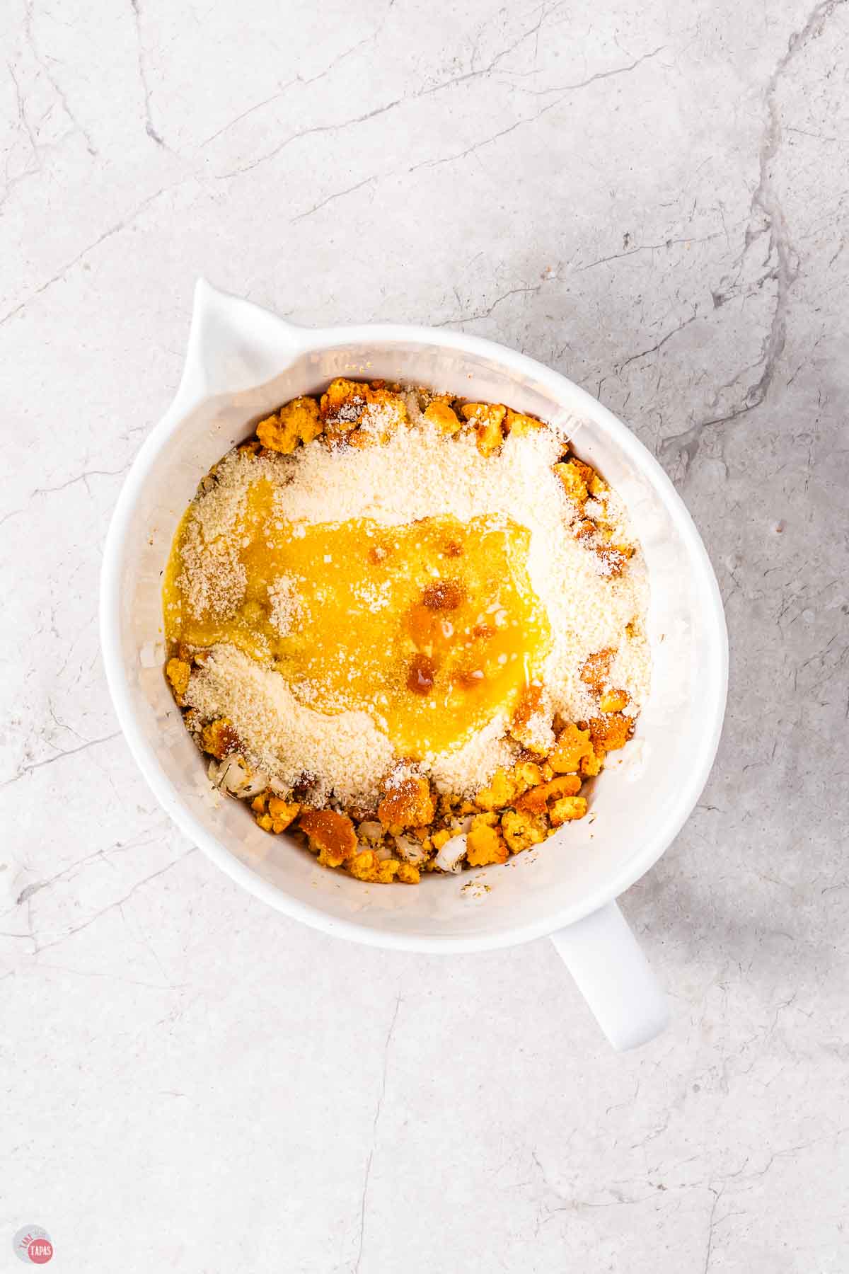 white mixing bowl with dressing mix and melted butter and cheese on top