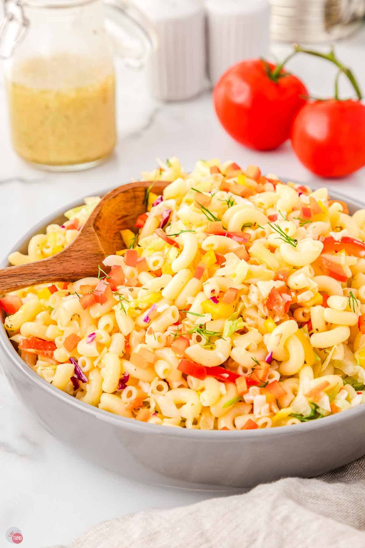 bowl of macaroni salad with a wood spoon