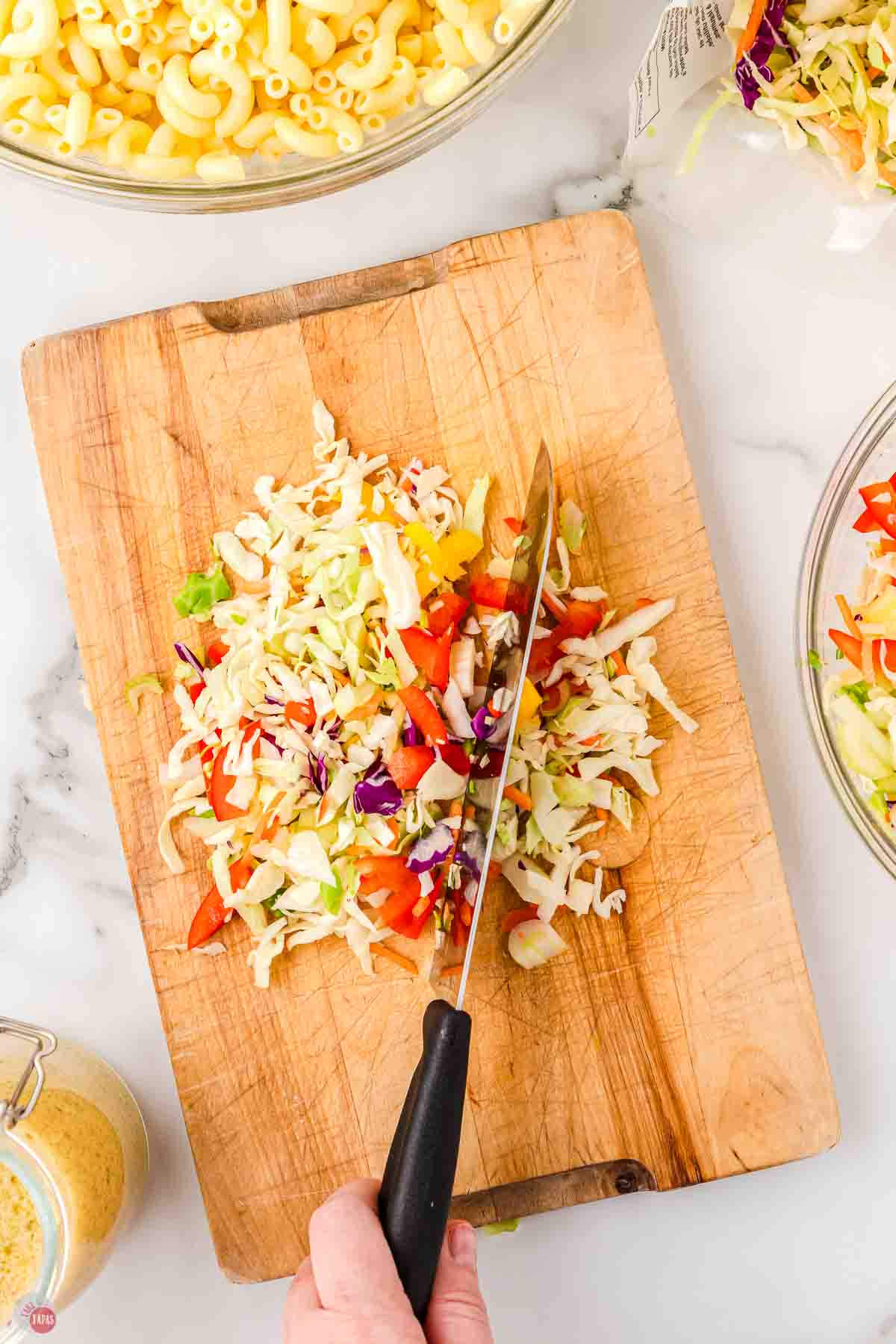 wood cutting board with knife chopping vegetables