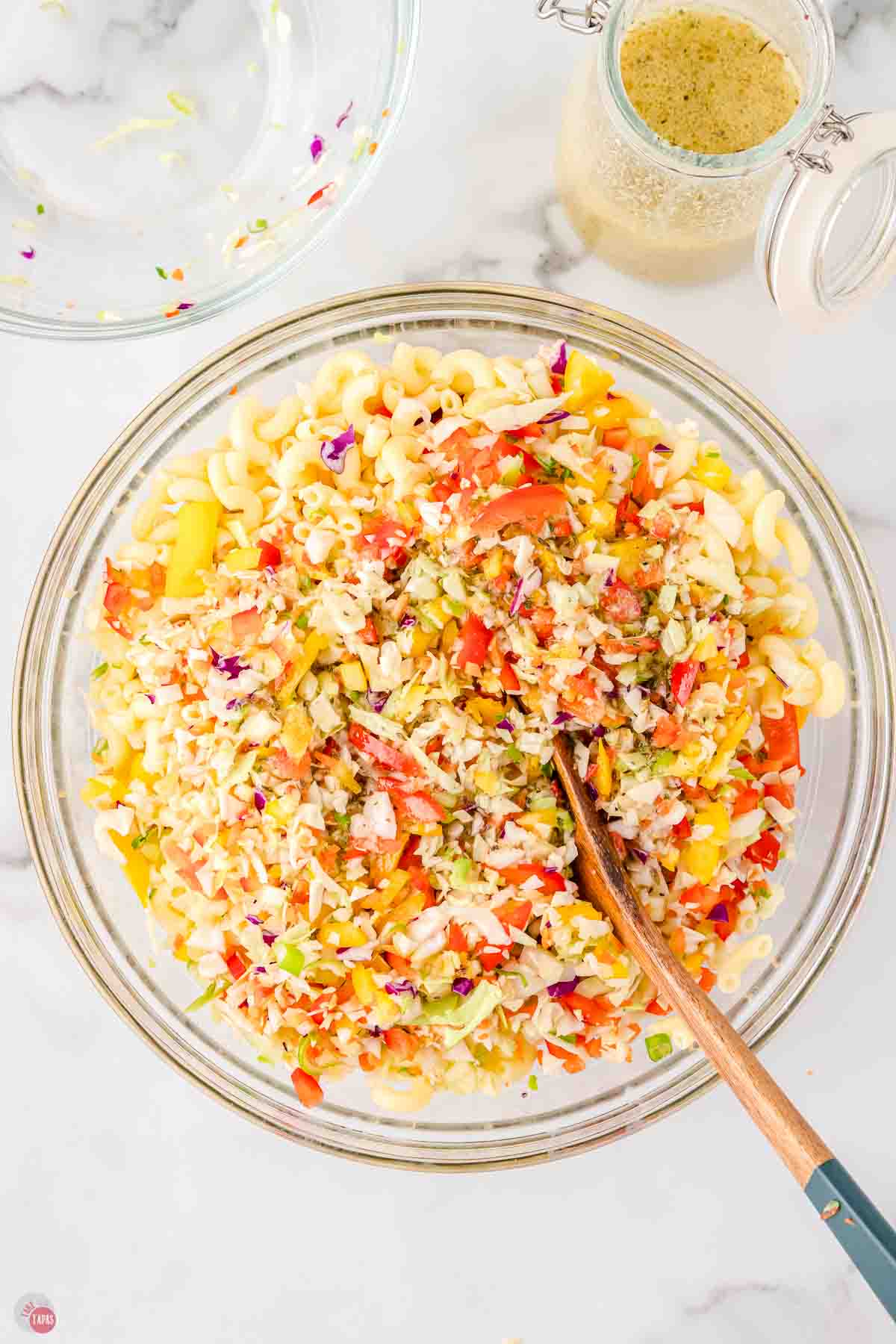 clear mixing bowl with pasta salad in it
