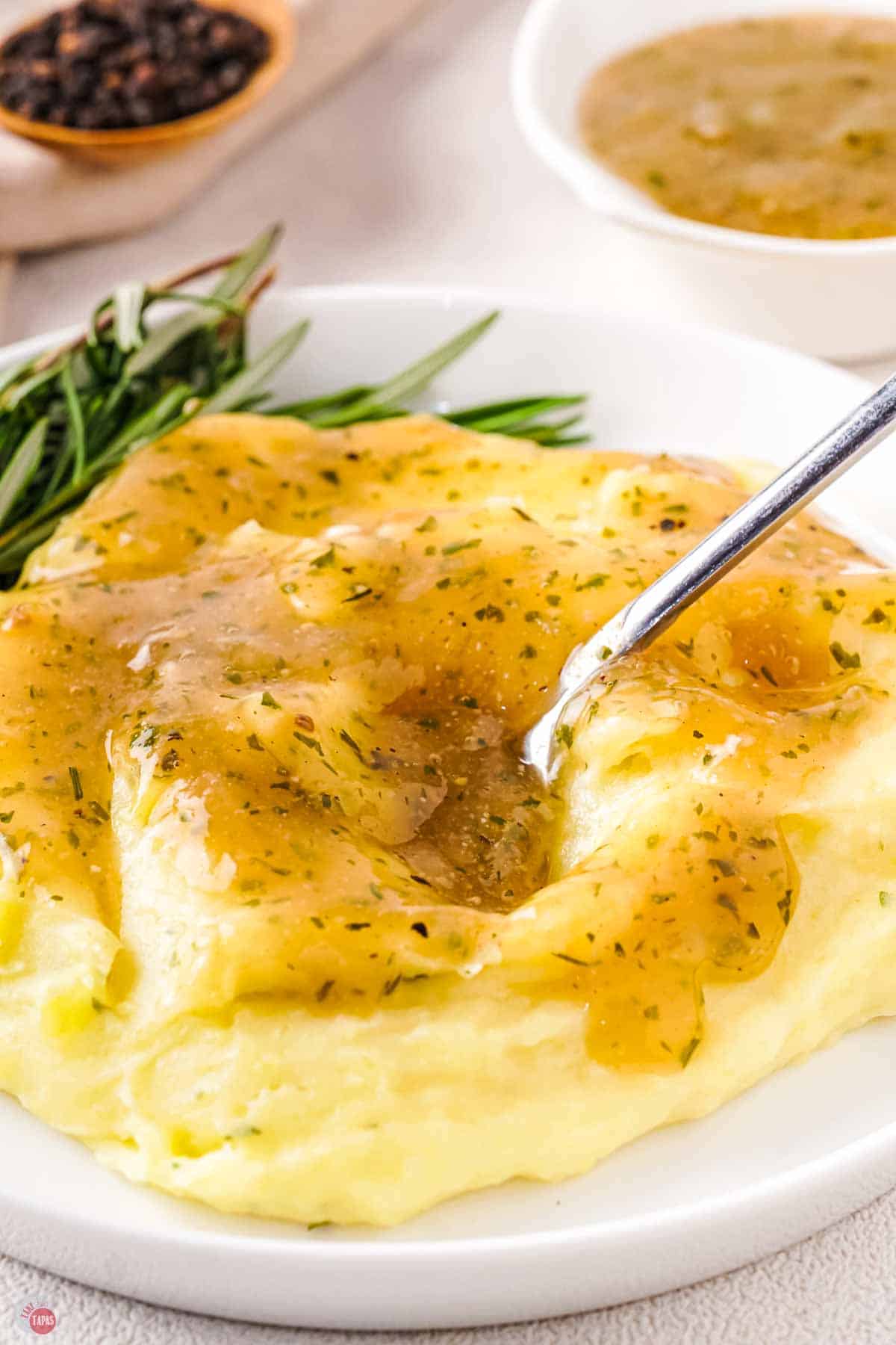 close up of a plate of mashed potatoes with au jus gravy on top