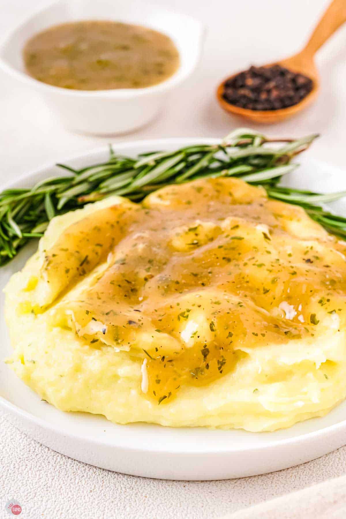 pile of mashed potatoes on a white plate topped with gravy
