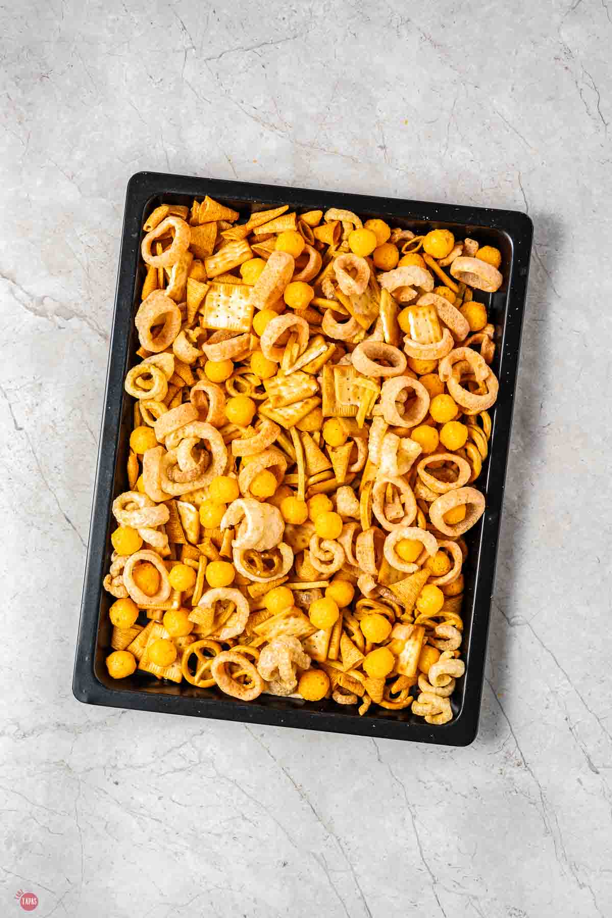 baking sheet of crunchy snacks all mixed together