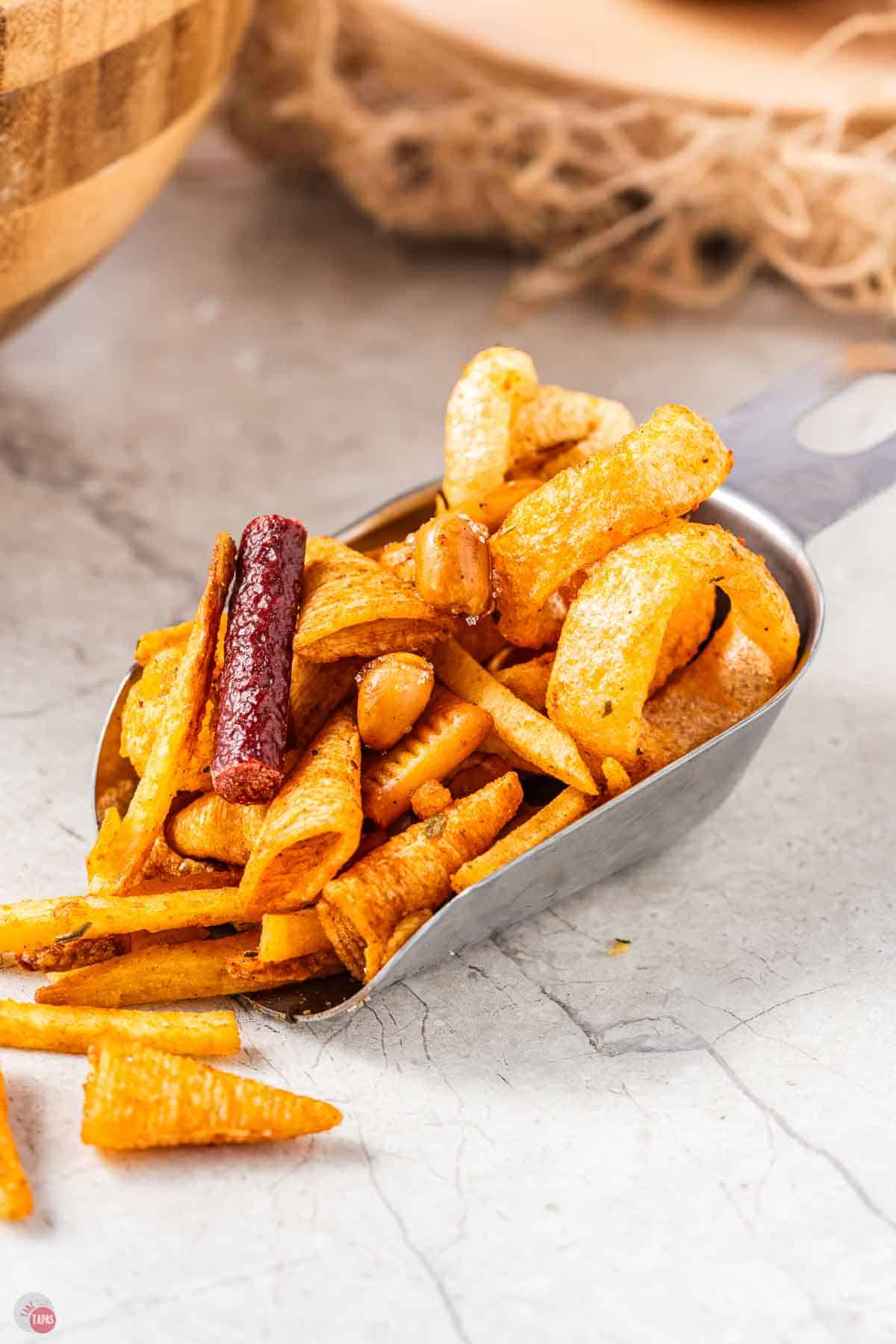 metal scoop with mix of snacks in it