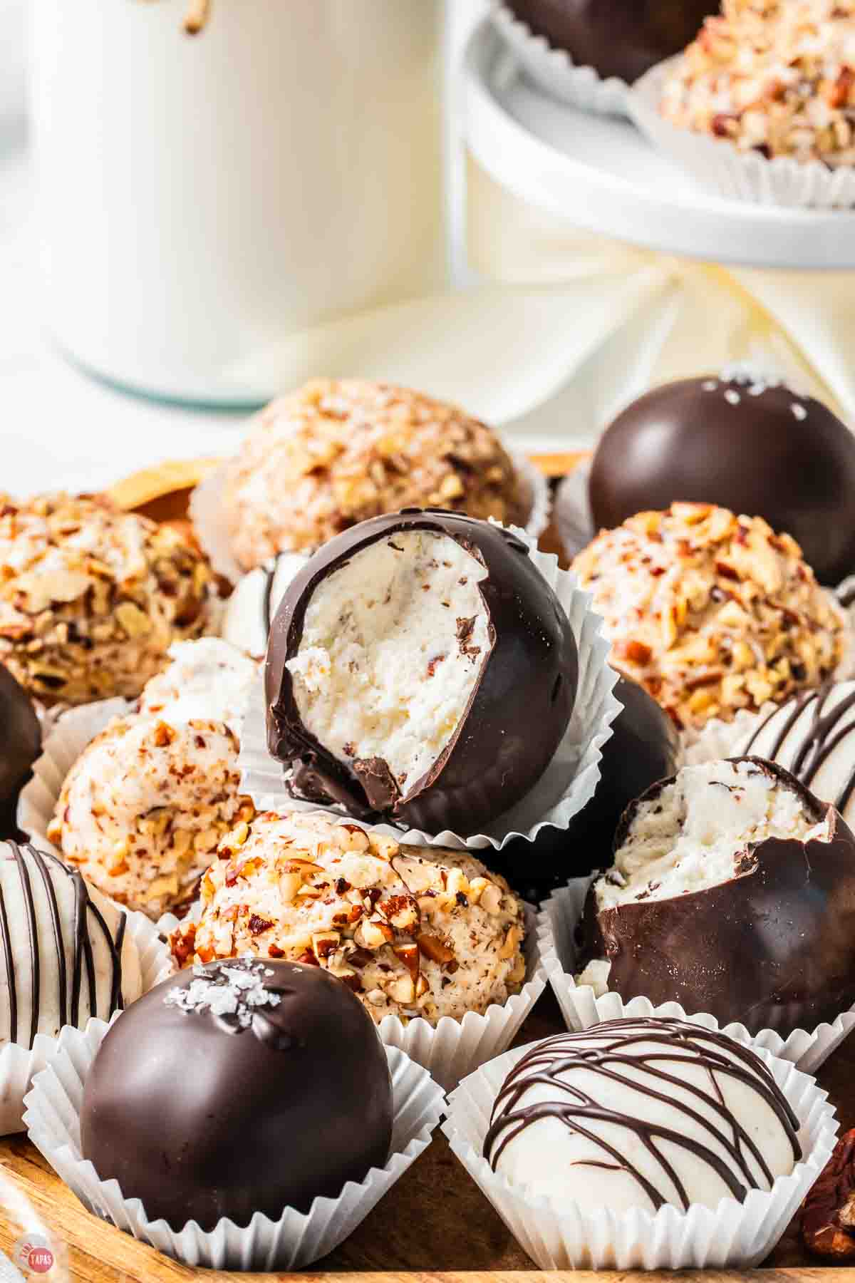 bourbon ball, coated with chocolate, on a stack with a bite missing