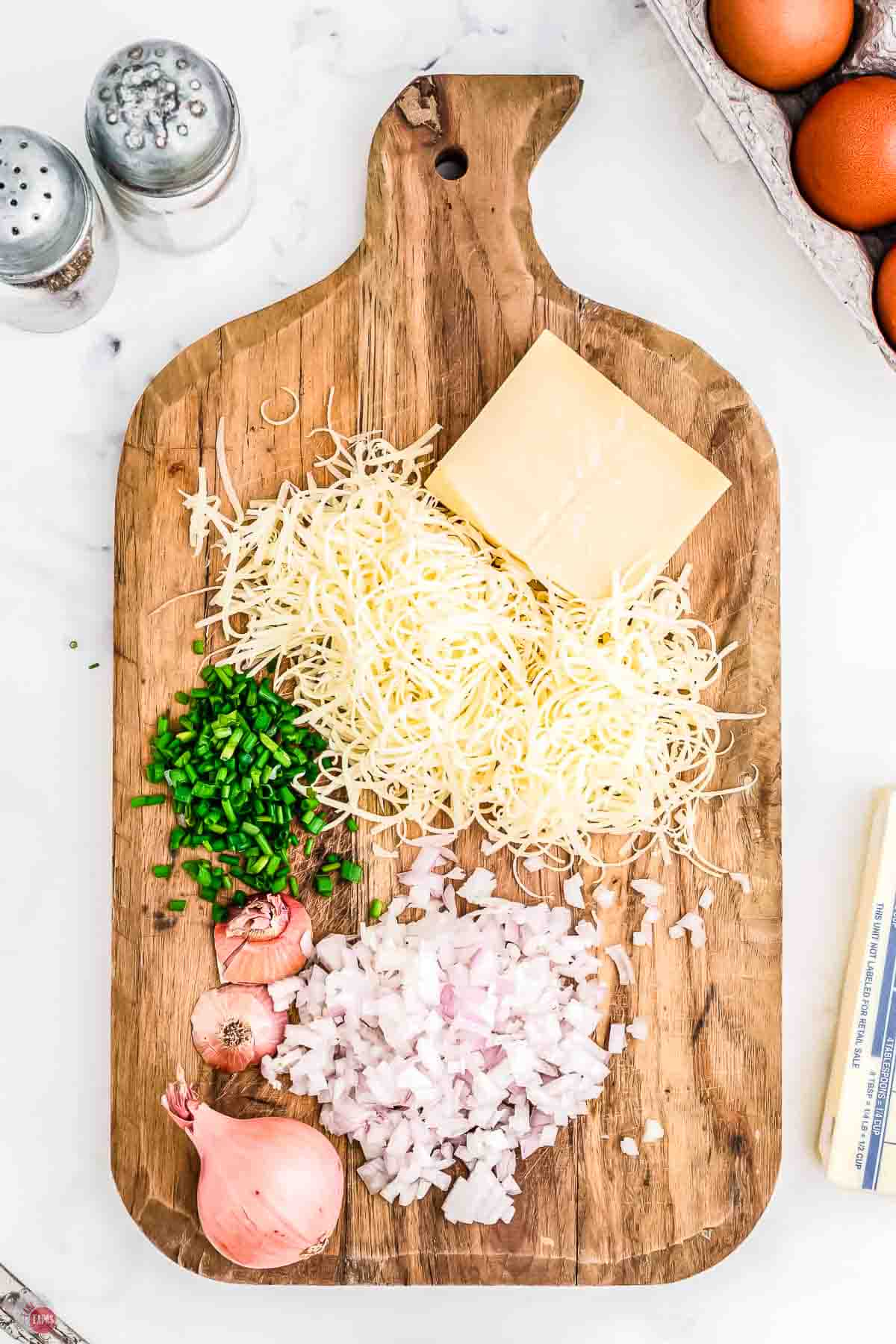 cutting board with shredded cheese and chopped onions