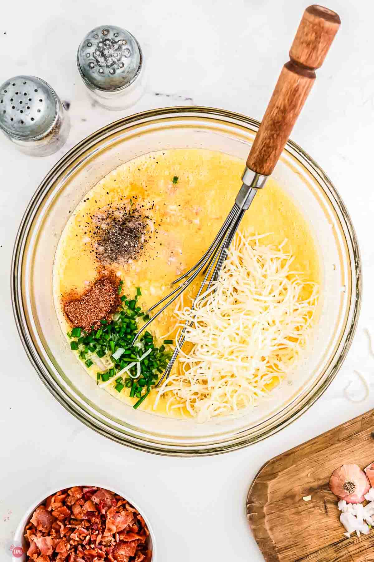 clear bowl with beaten eggs and spices in it