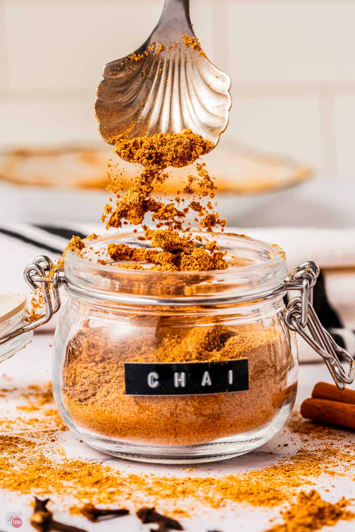 small jar of chai spice with a spoon scooping some out