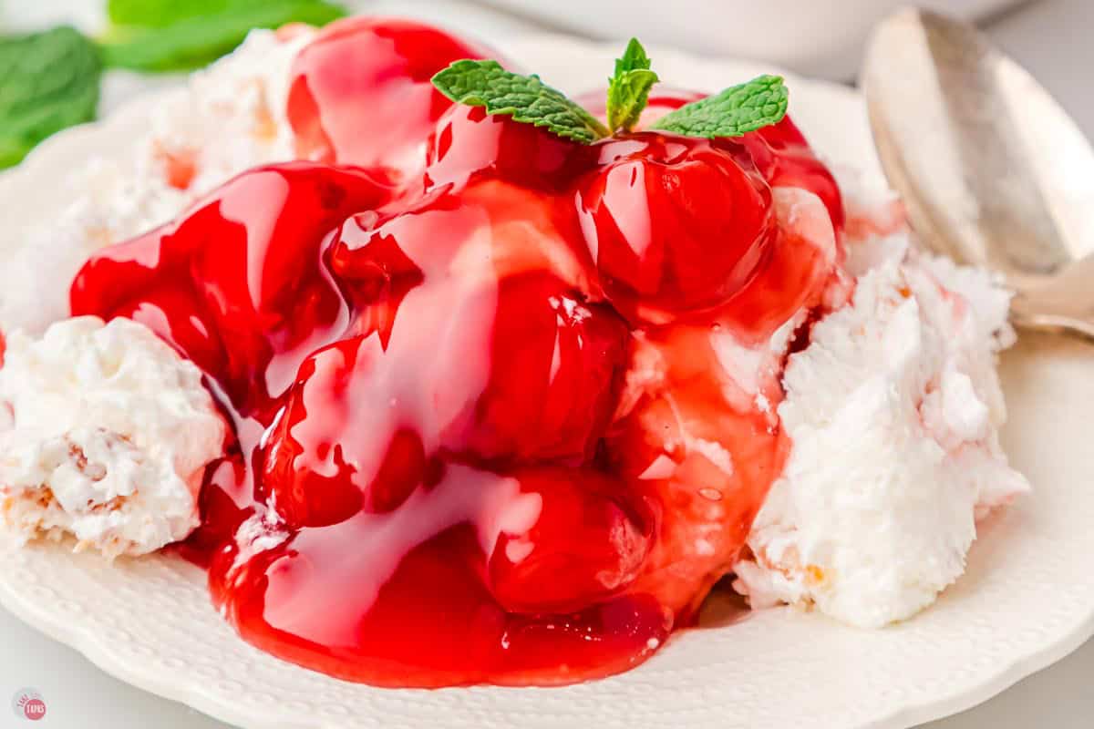 close up of cherries in the snow with a mint leaf