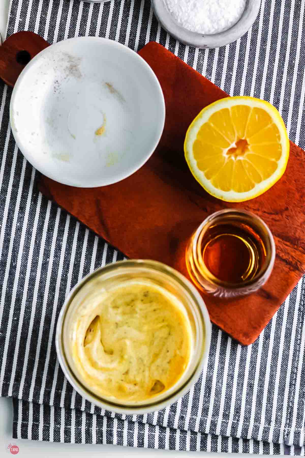 jar with thick, yellow dressing on a striped napkin