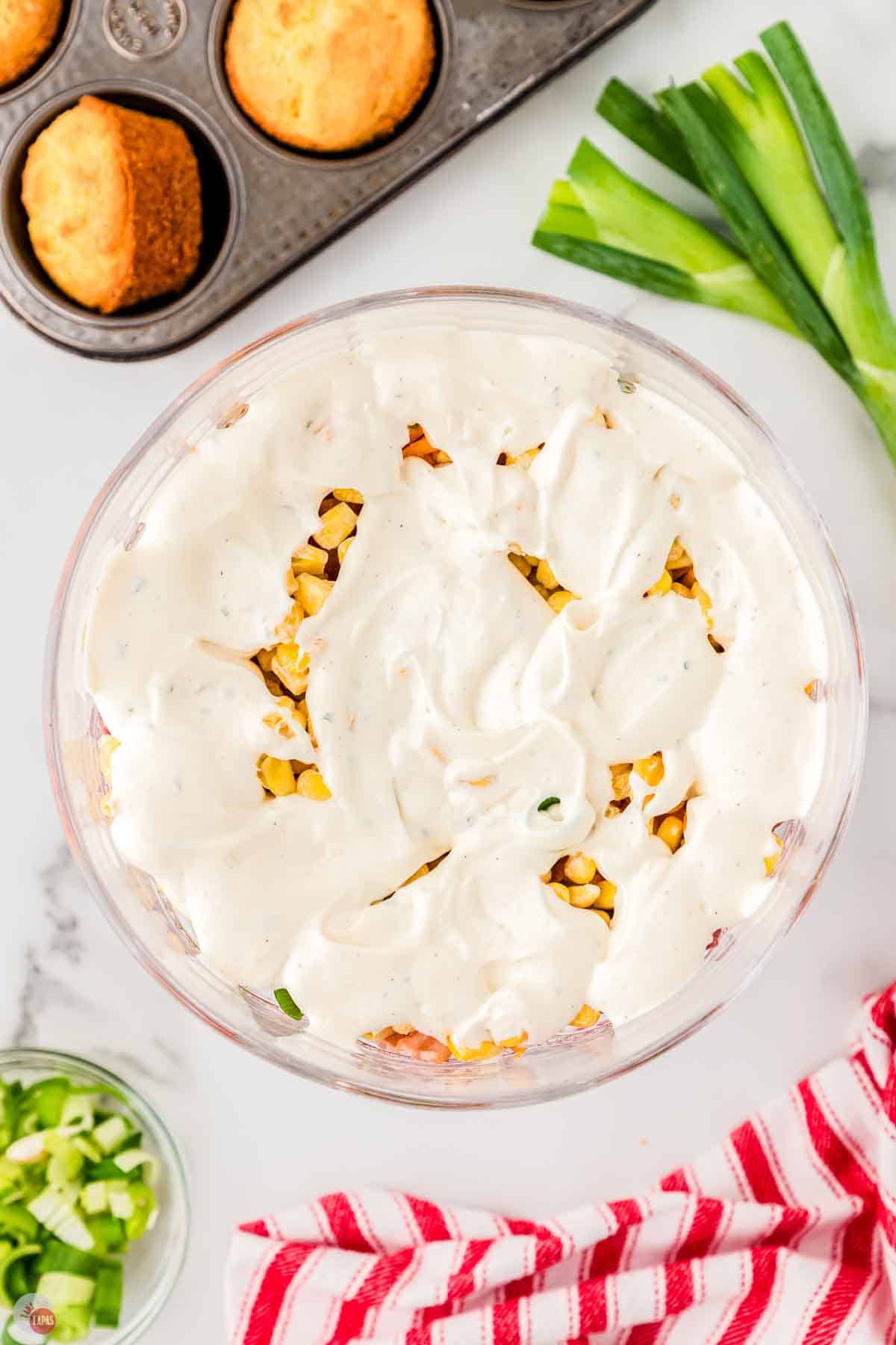 clear bowl with vegetables topped with dressing