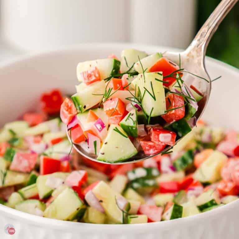 bowl of tomato cucumber salad with a silver spoon