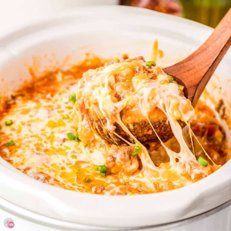 close up of wood spoon scooping a cheese recipe out of a white bowl