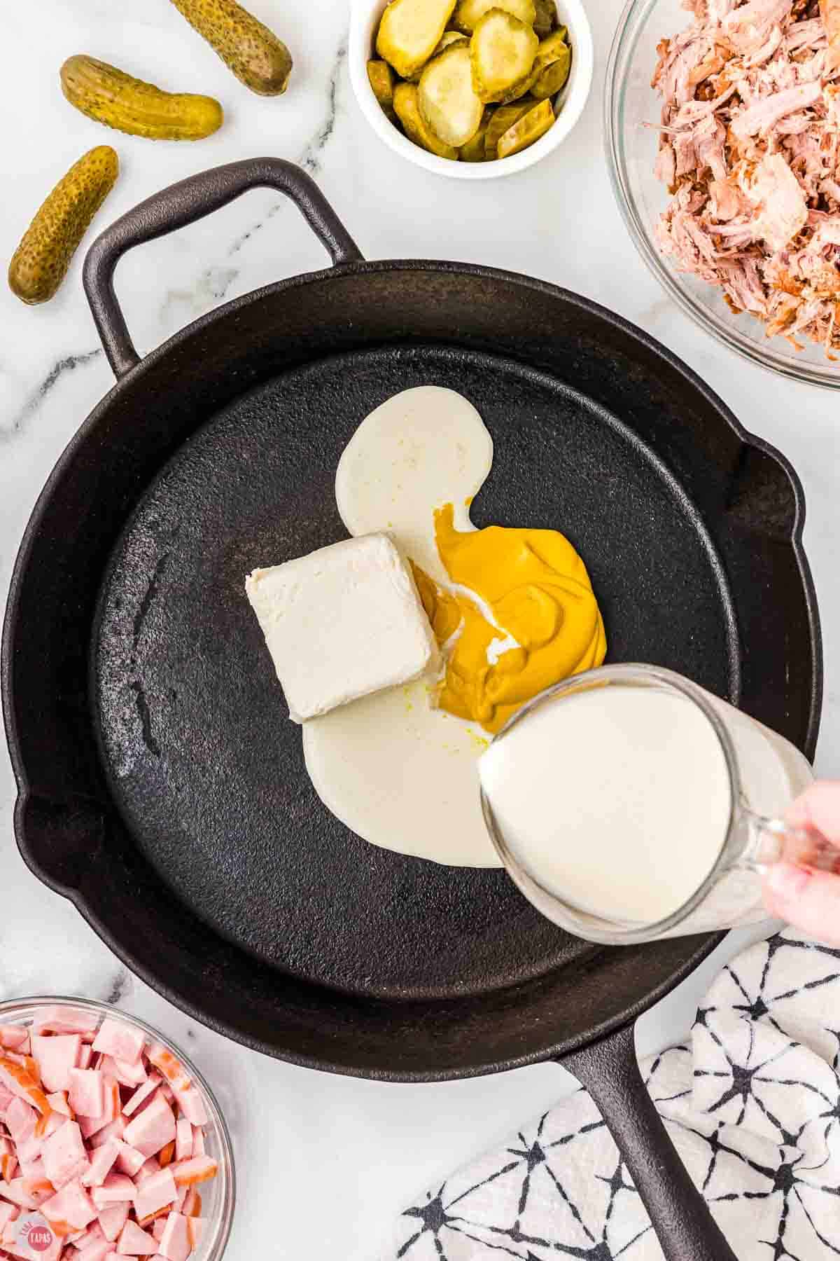 mustard cream sauce cooking in a black skillet
