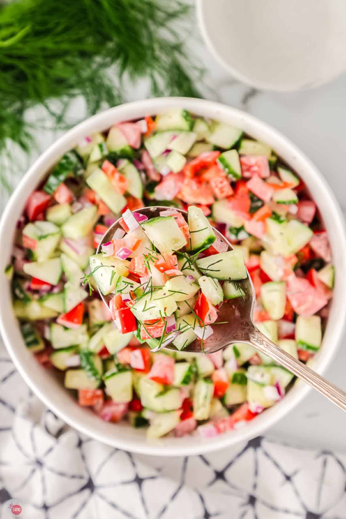 cucumber tomato salad in a white bowl