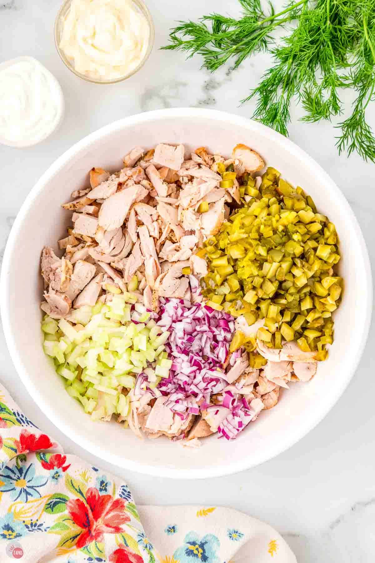 white bowl with shredded chicken, pickle relish, and onions