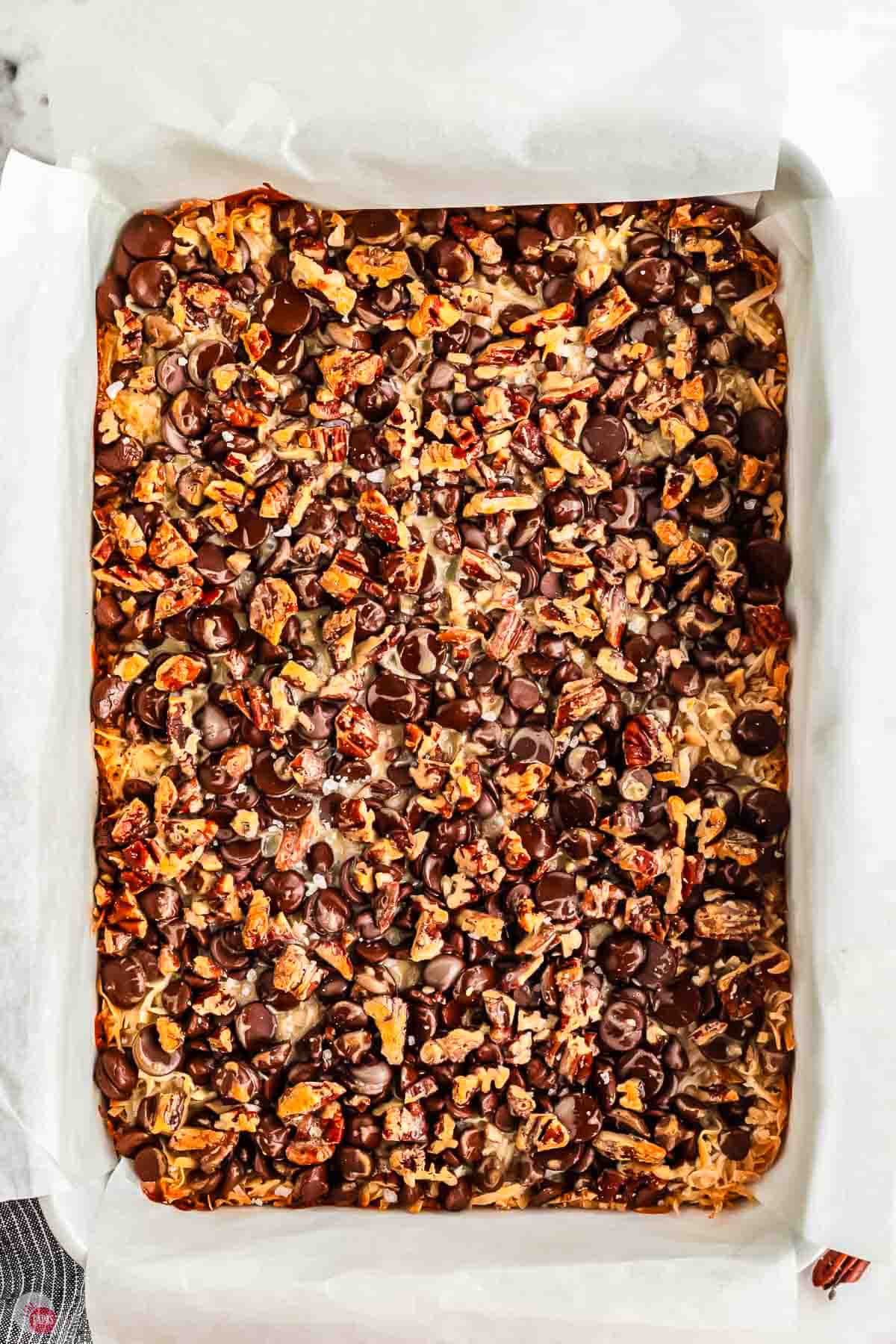 baked 7 layer bars in a baking sheet with parchment paper